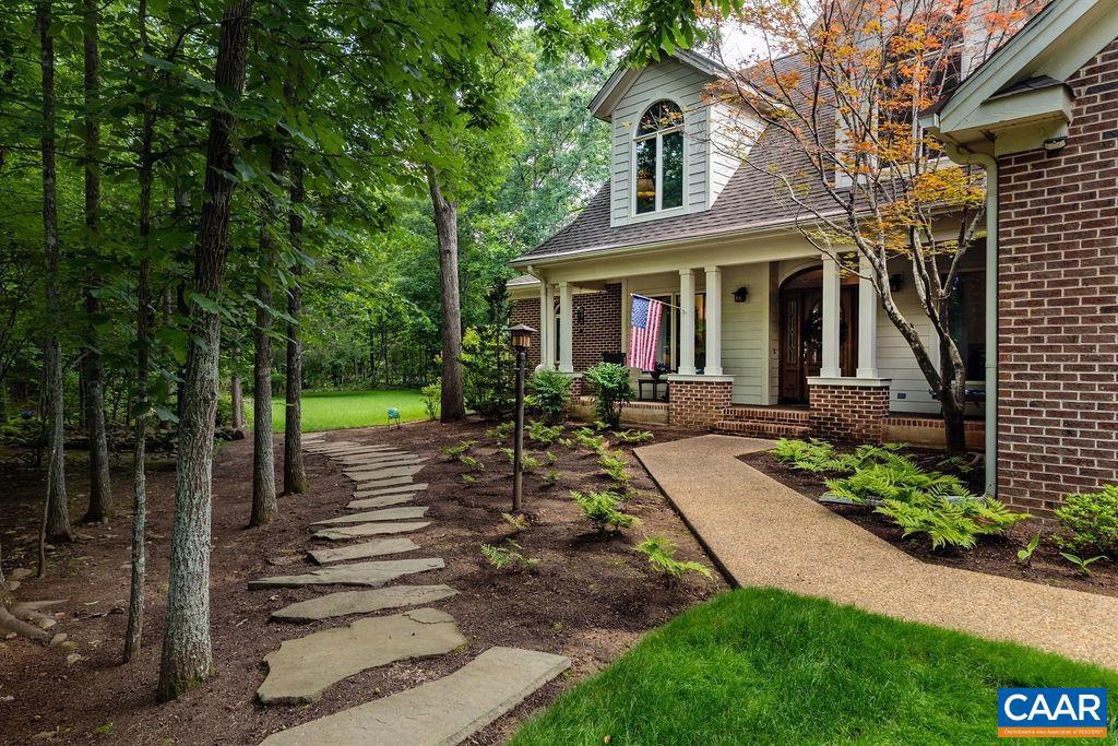 Exquisite and sophisticated, this home offers refined living on nearly 2 wooded acres with picturesque views and a serene setting. thoughtfully designed with timeless elegance, the interior is bathed in natural light and filled with stunning details, including oversized windows, skylights and hardwood floors throughout the main level. A soaring 2 story foyer and gorgeous oak front door sets a welcoming tone, leading to a front living room and a formal dining room, ideal for seamless entertaining. The gourmet kitchen is both stylish and functional, featuring beautiful quartz kitchen countertops, stone backsplash, all stainless appliances, custom cherry cabinets and a large walk-in pantry and separate utility closet. The adjacent sun room gives access to the large back porch looking out over lush landscaping.