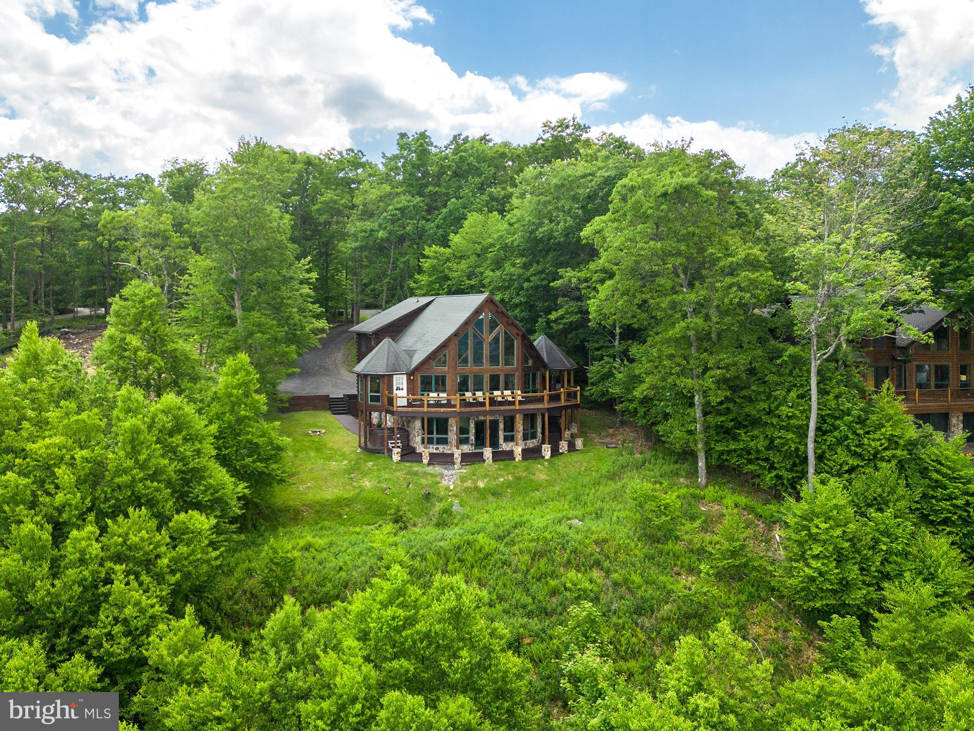 Mountain & Water views for miles! Breathtaking five bedroom log home with expansive lake and mountain views located in the mountaintop community of Deep Creek Highlands atop Wisp Mountain. This 3,400SF home offers an open floorplan, hardwood flooring, 2 stone fireplaces, spacious master bedroom, and granite counters. New laminate wood flooring on the lower level. Established rental "Vista Bonita" . Community amenities include an outdoor swimming pool, tennis court, playground, walking trails, pavilion and lake access area nearby.