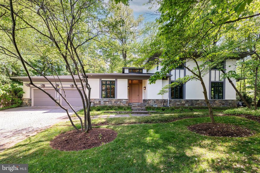 Located in Chesterbrook Woods—one of McLean’s most sought-after neighborhoods—5933 Woodley Road offers true main-level living with generous space to grow, entertain, and enjoy everyday life, all just one stoplight to Washington, DC. 

Custom built in 1998, this 5 Bedroom, 3.5 Bathroom home sited on a .47-acre lot thoughtfully expresses a mid-century modern design with clean lines, integrated built-ins, expansive windows, and soaring ceilings, creating a light-filled, open atmosphere that feels both sophisticated and warm. 

The main level is tailored for effortless living, featuring a spacious primary suite, mudroom with laundry, and direct access to the two-car garage—all on one floor. Enter through a dramatic two-story foyer into beautifully proportioned living spaces, including a sunlit great room with 10’-foot tray ceiling, custom cabinetry and a gas fireplace, a formal dining room with built-ins, and a private office with double doors. The kitchen is well-appointed with granite countertops, quality appliances, and a seamless connection to the breakfast area and outdoor spaces, perfect for everyday living and entertaining. The primary suite is a quiet retreat, complete with an adjacent sitting room accessed via pocket doors - ideal for a private office, nursery, den, or additional bedroom. The en-suite bath offers dual vanities, a jetted soaking tub, walk-in shower with bench, and a separate water closet, along with abundant natural light. A well-appointed powder room is also conveniently located on the main level. 

Upstairs, three generously sized secondary bedrooms, one with en-suite bath and the other two with access to a full hall bathroom, provide flexibility for family and guests, while the expansive unfinished lower level offers incredible potential—whether you envision additional living space, a home gym, theater, or all of the above. 

Recent updates, including a new roof, refinished hardwood floors, new carpet, and refreshed interiors enhance both comfort and peace of mind, while the home’s thoughtful layout and quality construction provide a rare opportunity to move in and make it your own.  

Surrounded by mature trees and set on a picturesque .47-acre lot, this property offers a rare blend of location, design, ease, and livability with a tranquil setting and easy access to parks, top-rated McLean schools, shopping, and major commuter routes.