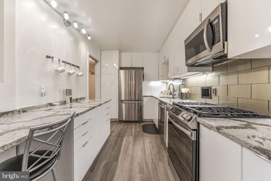 Welcome to a one-of-a-kind unit in The Willoughby. Kitchen was designed with functionality + beauty in mind. Shiny finish cabinets  not only sparkle, but are easy to clean .  Every imaginable feature included: large lazy Susan corner cabinet, spice drawer, pullout drawers are sufficiently deep for large pots and pans and easy on your back! Under-counter filter for water eliminates need to buy bottled water. Extra-large Samsung  fridge has bottom freezer and excellent capacity. Other stainless appliances include 3-level dishwasher and 5-burner gas stove.  Wall cabinets are not only tall, but deep enough for your platters and large plates. Luxury Vinyl Tile completes this thoughtfully planned out kitchen.  Sliding doors keep odors in and work space out of sight.  Additionally, there is an area in the kitchen where you can drink your morning coffee while you catch up on emails.  The patio is at least as large as the living room.  Current owner has planted azaleas that bloom in Spring and Fall, but it is yours to landscape as you wish. Great private entertaining area right off the living room, but viewable from the bedroom as well as the den/guest room/office which is a welcome feature in a one-bedroom unit. Blinds in the bedroom are adjustable to block light or not.  Generous closet space throughout.  Additional storage room on the 8th floor holds up to 5 of your extra items (suitcases, seasonal decorations). Gas, electricity, water, master insurance  included in condo fee. The chandelier in the dining area DOES NOT convey. The building has 24/7 concierge,  a book club, speaker series, activities on the rooftop from time to time. In addition to the pool, there is a sundeck, library and rooftop lounge with open wi-fi. Current projects include garage updating and installation of fire alarm.  The building has bike storage.  Additional bonus to this unit:  two parking spaces included on level G4 right across from the North elevators.  Tandem spot.If you don't need both spots, you can rent them out. Seller is licensed real estate agent.