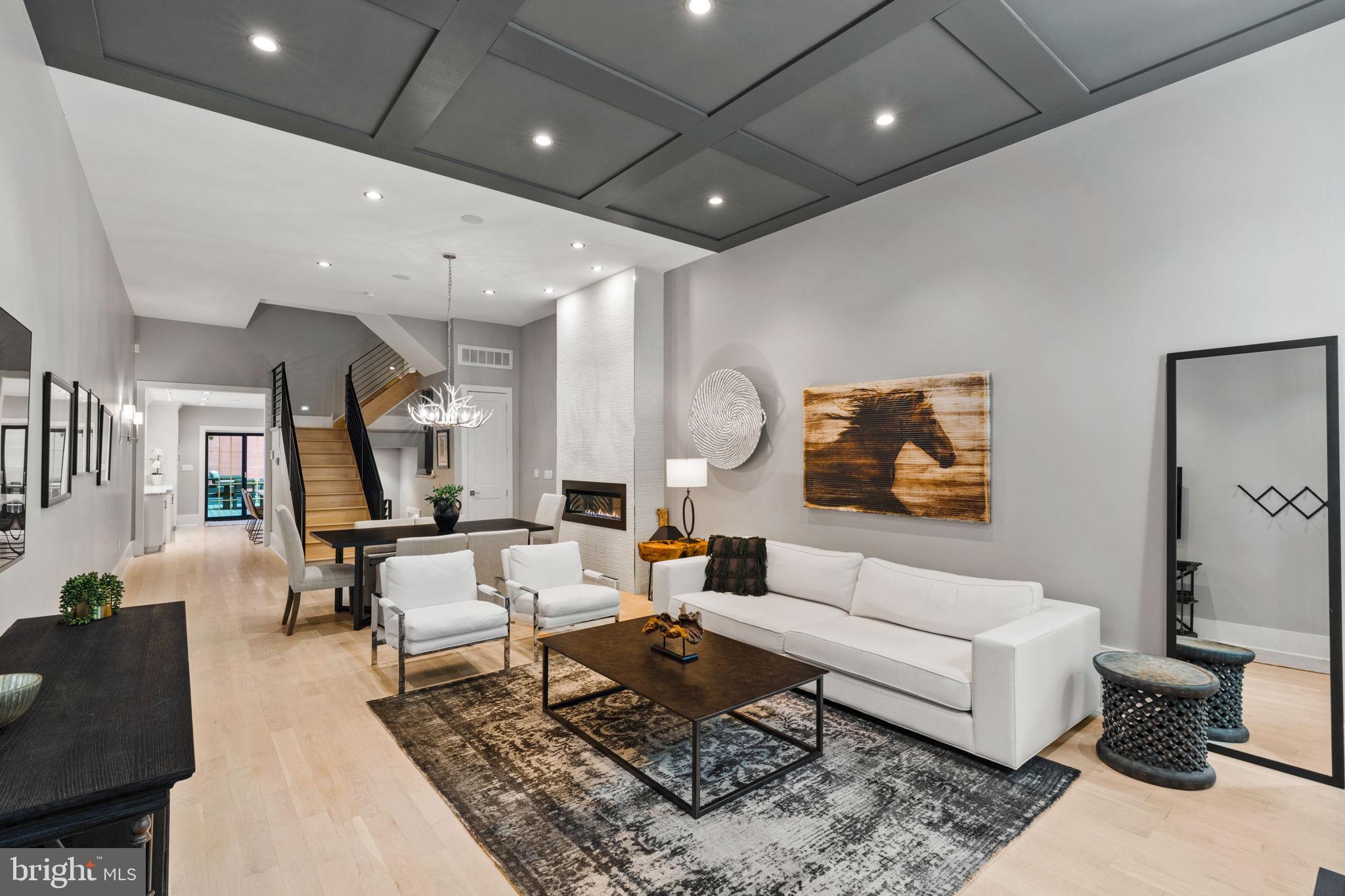 Mint-Condition Townhouse with Parking & Tax Abatement | With every detail thoughtfully reimagined, 905 Pine offers a historic facade with a contemporary interior designed at the highest level of craftsmanship. Built in 1900 and meticulously renovated in 2019 by Piper Crown Construction & Maxim Capital Partners, highlights of this prized Washington Square West property include an open first level with a designer kitchen that flows into an enclosed courtyard, a well-appointed primary suite, two inviting outdoor spaces, a finished lower entertaining level, PARKING, and TAX ABATEMENT. With over 4,600 square feet between 5 levels, this urban mansion is entirely spacious and offered in mint condition. Step up from the sidewalk, past a storied facade, and enter into the open entertaining space. Here, two oversized windows cast tremendous daylight into the front living space which features a 12’ coffered ceiling, a linear fireplace with floor-to-ceiling Porcelanosa tiling, a shelved coat closet, and a convenient powder room. Elegant sconces lead from the front living and dining space to the professional-grade kitchen. The kitchen is framed by marble tile walls with crown molding, white wood shaker cabinets, striking quartzite countertops, and sliding Pella doors facing the sunny courtyard. In addition to conveniences like the drop-down breakfast bar and wall pantry storage, the kitchen appliances were thoughtfully selected: a 36” SubZero refrigerator, a 48” Wolf dual-convection range and microwave drawer, a Zephyr range hood, and an Asko dishwasher. A spacious outdoor courtyard extends from the kitchen and features a raised natural gas fire pit, a stone island with a built-in Wolf grill, and floor lighting. There is a private gated entrance at the back of the courtyard leading to tree-lined Clinton Street, perfect for quick runs to and from. With the living room that flows into the dining area, which leads into the kitchen and open courtyard, the resident can move about the property and host with ease. The upper levels feature 4/5 bedrooms, 4 full bathrooms, a den with a wet bar, and a roof deck. An illuminated stairwell guides from one suite to the next, with the primary bedroom chief among them. The primary is marked by its 12' soaring ceiling, oversized windows, tasteful bedside pendant lights, and a tray ceiling with cove lighting. This suite also offers a dressing room lined with custom California Closets shelving and a spa-like ensuite bathroom. The primary bathroom is complete with Porcelanosa wall and radiant floor tiling, a freestanding soaking tub, a frameless glass shower with a built-in bench, a water closet, and a quartz vanity with dual sinks. The additional bedrooms feature en-suite bathrooms with contemporary tiling and shelved closets. A third-floor lounge is outfitted with a wet bar and beverage refrigerator. A laundry room furnished with quartz countertops, cobalt blue shaker cabinets, front-loading Electrolux appliances, and a deep sink is accessed via the lounge. The top floor of the property serves as an impressive flex space with soaring ceilings; this room can function as a gym, media room, or the fifth bedroom. A roof deck, with views of the neighborhood and Center City skyline, extends from the top floor and is complete with Trex decking and illuminated posts. Downstairs, a finished lower level is expertly designed and offers a wet bar with a hammered nickel sink, custom cabinetry and island seating by Laslo Kitchens, two SubZero wine cellars, and floating shelves with upper sconces. The basement is additionally wired for a large television. Additional amenities include CAT5 wiring, an indoor/outdoor sound system with Control 4 technology, a security system with cameras, keyless entry, dual-zone HVAC, garage parking, and a tax abatement through 2029. Disclaimers: Compass and its licensees make no guarantee regarding tax or square footage amounts; buyer to independently verify.