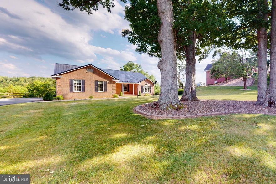 Wow, look at the curb appeal of this all brick rancher donning a brand new metal roof.  Over 4000 sq ft finished living space on 2 floors.  On the MAIN LEVEL is the eat in kitchen with a fantastic workflow setup, bar setting and French doors leading to the upper level patio.  Don't miss the majestic mountain VIEWS from this patio.  Back inside the kitchen opens to a HUGE Living Room-over 400 sq ft in just this one room!  Back the hallway, is a spacious Primary Bedroom & Bath with a oversized walk-in closet.  Two additional bedrooms and another full bathroom.  Laundry Room, Kitchen Pantry and Mud Room is perfectly situated between the garage and kitchen.  2 Car Garage, Storage Area & Attic Storage complete the main level.  You may never need to go to the basement.  Head downstairs where there are the 4th & 5th bedrooms with another full bathroom.  A Family Room with windows and a door that leads to a walk-out patio.  Storage is not a problem in this home as you will find several storage areas in the basement.  Large mature trees in the front yard are an added bonus.  Amish Built home with Central Electric Heat & Air and public water & sewer.  In a quiet, established neighborhood with city maintained roads.  Only a 2 mile drive into town for the conveniences of shopping, restaurants, library and banking.  Be sure to call for a showing today before it's too late.