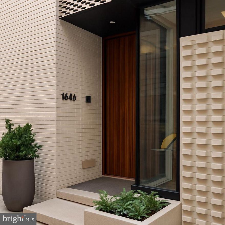 1646 Carlton Street is a masterclass in contemporary architecture and modern luxury.

Set within the gated NOVO community in Logan Square—just steps from the city’s most celebrated museums—this 28-foot-wide, 4-bedroom, 6-bath residence blends dramatic design with impeccable craftsmanship.

The exterior makes an unforgettable first impression with intricate modern brickwork, custom metal cladding, striking window compositions, and a floating stone terrace. A custom solid walnut pivoting door leads into a gracious foyer, where a first-floor office or guest suite faces the street, complete with custom built-ins and a corner window. Direct interior access to the three-car garage adds ease and convenience.

Throughout the home, radiant heated floors provide unparalleled comfort and refinement—visible evidence of the home’s elevated standard of construction.

Ascending to the main living level, you pass a sculptural powder room defined by its dramatic stone backsplash. The primary living floor unfolds into a breathtaking open space—minimalist yet warm—anchored by a European chef’s kitchen with a massive Super White quartzite island and matching full-height backsplash. Appliances are all top-tier, including a Thermador built-in coffee maker, double wall ovens, integrated knob cooktop, drawer microwave, Sub-Zero refrigerator, and pot filler. Custom lighting adds a gallery-like ambiance.

Adjacent to the kitchen, the living room is nothing short of extraordinary, offering a double-height volume, cove lighting, and a sleek gas fireplace wrapped in porcelain. Floor-to-ceiling glass opens to a private balcony with pedestal pavers, creating effortless indoor/outdoor connectivity. A dining area with a fully outfitted butler’s pantry completes this level, supported by thoughtful details such as linear slot diffusers and large-format floor tiles.

Take the floating staircase—or elevator—to the mezzanine level, which overlooks the living room below. This floor includes a lounge or family room and two well-proportioned bedrooms, each with en-suite baths.

The primary suite occupies an entire level and functions as a private retreat in the sky. A full wet bar with stone counters and beverage refrigeration anchors the landing, and a concealed door reveals the laundry room. The bedroom features soaring ceilings and a dramatic 10-foot Pella sliding glass wall opening to a private balcony. The walk-in closet resembles a boutique dressing room, complete with center island and custom organizers. Pocket doors lead to the spa-inspired bath, featuring a Porcelanosa soaking tub, expansive glass shower, and a floating double vanity with wall-integrated Brizo faucets.

At the top of the floating staircase, an additional half bath precedes the rooftop terrace—over 800 square feet of private outdoor living. This extraordinary space includes a louvered pergola, an outdoor kitchen with a stainless grill, and a luxurious Bullfrog Stil7 tub. Panoramic skyline views make this rooftop one of the most impressive private outdoor spaces in the city.

The lower level echoes the feel of a boutique hotel lounge, featuring a custom bar, integrated sound system, and a separate fitness room (4th bedroom) and a full bath. The home’s smart-tech infrastructure is extensive, including Lutron Lighting System, automated shades by Allure, multiple HVAC zones, whole-home audio, and more.  

1646 Carlton Street is not just a residence—it is a work of modern art, offering sophisticated architecture, exceptional craftsmanship, and a lifestyle unmatched in the heart of Philadelphia.