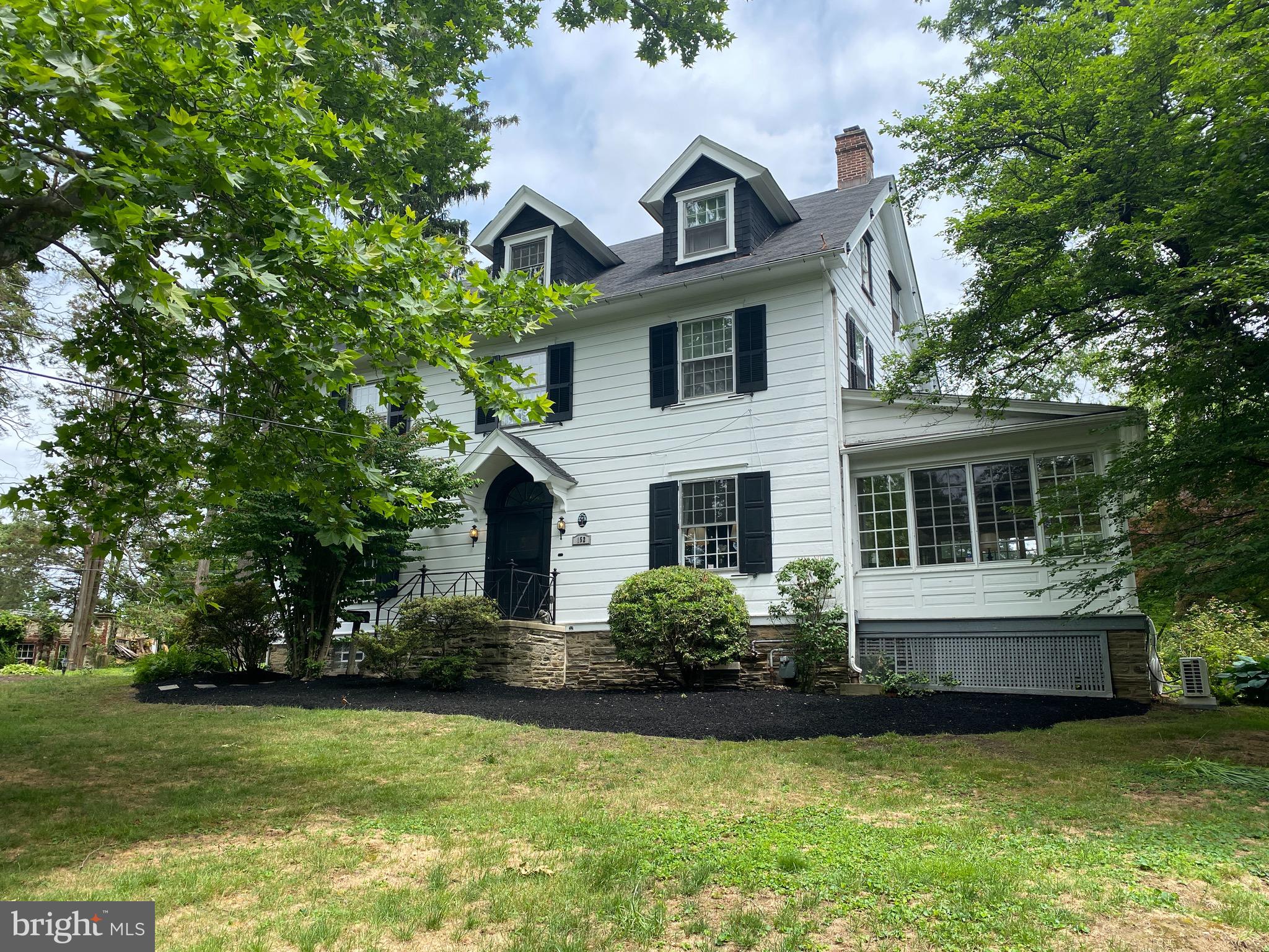 **Open House Sunday, June 13th from 1:00 to 3:00**  Welcome to 152 Highland Avenue!  Gorgeous and stately home in the heart of the highly desirable Jenkintown Borough…exceptional!  Enter this special 1900 Colonial and, once through the foyer, this magnificent living room with paneled walls, a coffered ceiling, and historic detailed millwork will take your breath away!  Toss your belongings into one of three closets and relax on the built-in bench and to simply view this truly one of a kind room…stunning!  With the wood-burning fireplace, built-in glass-front bookcases, gorgeous hardwood floors, and the elegant inviting staircase, you will feel cozy and comfortable.  Through the living room, there is a bright and airy family room with private views of the outside through walls of windows…so beautiful.  The glamourous blue and white formal dining and its beautiful decorative fireplace is patiently awaiting the next dinner party.  Traveling from the dining room to the kitchen, there it is…the original Butler Pantry which has been warmly renovated to preserve the history of this room and the abundant storage it offers. The renovated kitchen boasts white cabinets, quartz counters with seating, a back staircase, built-in corner seating, and, yet, another coffered ceiling!  The details throughout this home are truly special.  Heading up the classic paneled staircase, you will enjoy the large primary bedroom with another decorative fireplace and a tiled bathroom.  There are four other bedrooms, one of which the owners use as a very convenient walk-in closet. The beautiful light shining through the large windows of this home create enchanting areas throughout the home.  The third floor offers two additional bedrooms, one of which is currently used as a work-out/yoga room and the other a home office.  There is a large storage attic space as well.  Let’s now go outside, shall we?  On over a half of an acre, this lovely home is situated on one of the prettiest streets in the Borough and the views do not disappoint.  Accessed from the kitchen or the family room, the private flagstone patio is always enjoyed as the trickling from the stone pond and the mesmerizing koi make this cozy area the perfect retreat to entertain and to relax.  Invite family and friends or simply curl up with a good book or two.  Either way, you and your family are sure to enjoy!   Ideally located...two blocks from the Jenkintown Train Station, two blocks from the Jenkintown Schools, and two blocks from the Jenkintown Shopping District where unique shoppes have so much to offer, a variety of restaurants and pubs, the Hiway Movie Theatre, and the historic Jenkintown Library...just to name a few.  Call to make your appointment now to visit this beautiful home!
