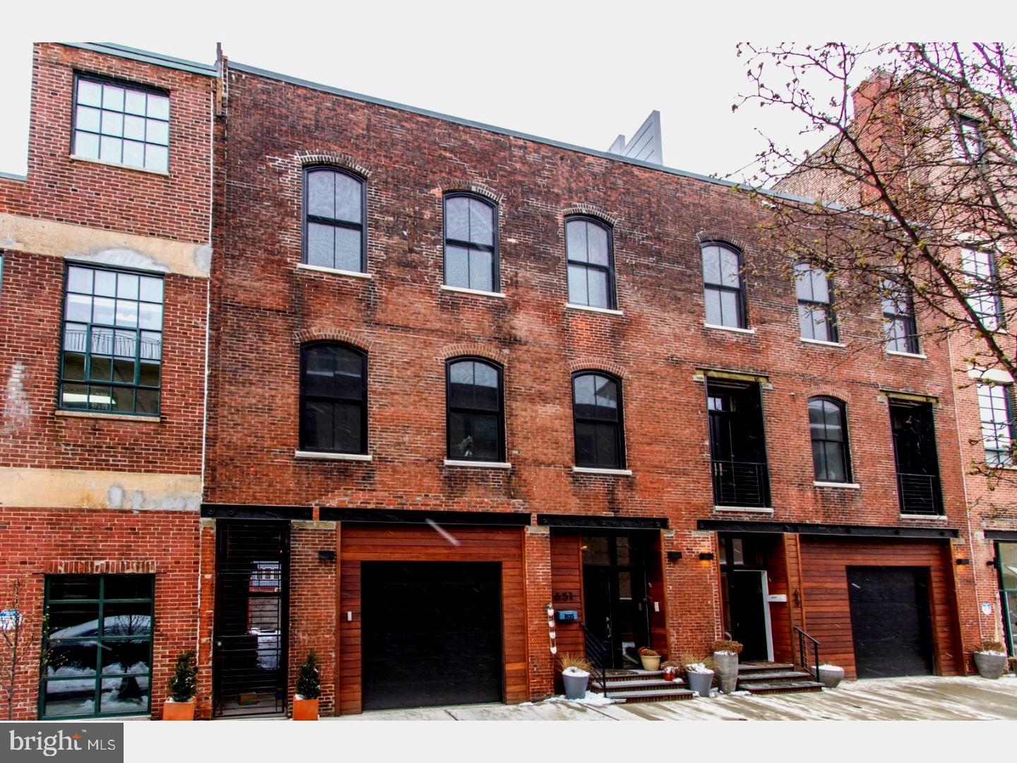 A true hidden gem on a rare private and gated street in the heart of picturesque and desirable Fairmount neighborhood. A historic warehouse restored and renovated with loving care by developers with an appreciation for the historical nature of the building and its outstanding original features. This 3800 sq. ft. home lacks for nothing and will provide its new owners with that rare combination of luxury and living history. You enter into a double height foyer and then move into a spacious den and full bath with exposed spiral architectural duct work, built in bookshelves, and french doors that lead into the rear yard and side alley. Wide plank wood floors throughout the house complement the abundant light streaming in from massive historically accurate arched windows. The modern, open concept layout continues upstairs where the exposed brick barrel vaulted ceilings are worthy of an Architectural Digest spread and enhance the airy modern industrial feel. Custom wood cabinets and quartz countertops flank the chef's kitchen with high-end GE Monogram appliances including double oven's, and a pasta filling arm. The alcove office space, dining room and living room with remote controlled fireplace round out the second level. The third floor has two spacious, light-filled bedrooms with custom closets, automatic window treatments, and a full bath with custom wood vanity and quartz countertop. Toes will never be cold because all bathrooms in this house have radiant heated floors. The master bedroom is a study in tranquility, with spacious custom walk-in closets and you won't want to ever leave the huge master bath with soaking tub, double custom vanity, and massive shower with steam system and Toto washlet toilet. The cherry on top of this magnificent house is the wet bar leading to the roof deck with 360 degree views of the city for elegant entertaining under the Philly skyline. No expense has been spared at this home and the features are endless: Lutron lighting system, tankless high capacity instant water heater, automated window treatments in all rooms, two zone heat/air with Nest thermostats. 9.5 years left on the 10-year tax abatement and there is the possibility to add two more bedrooms to the first floor as the neighboring house has done. This house is very lightly lived in as it was completed just 8 months ago.