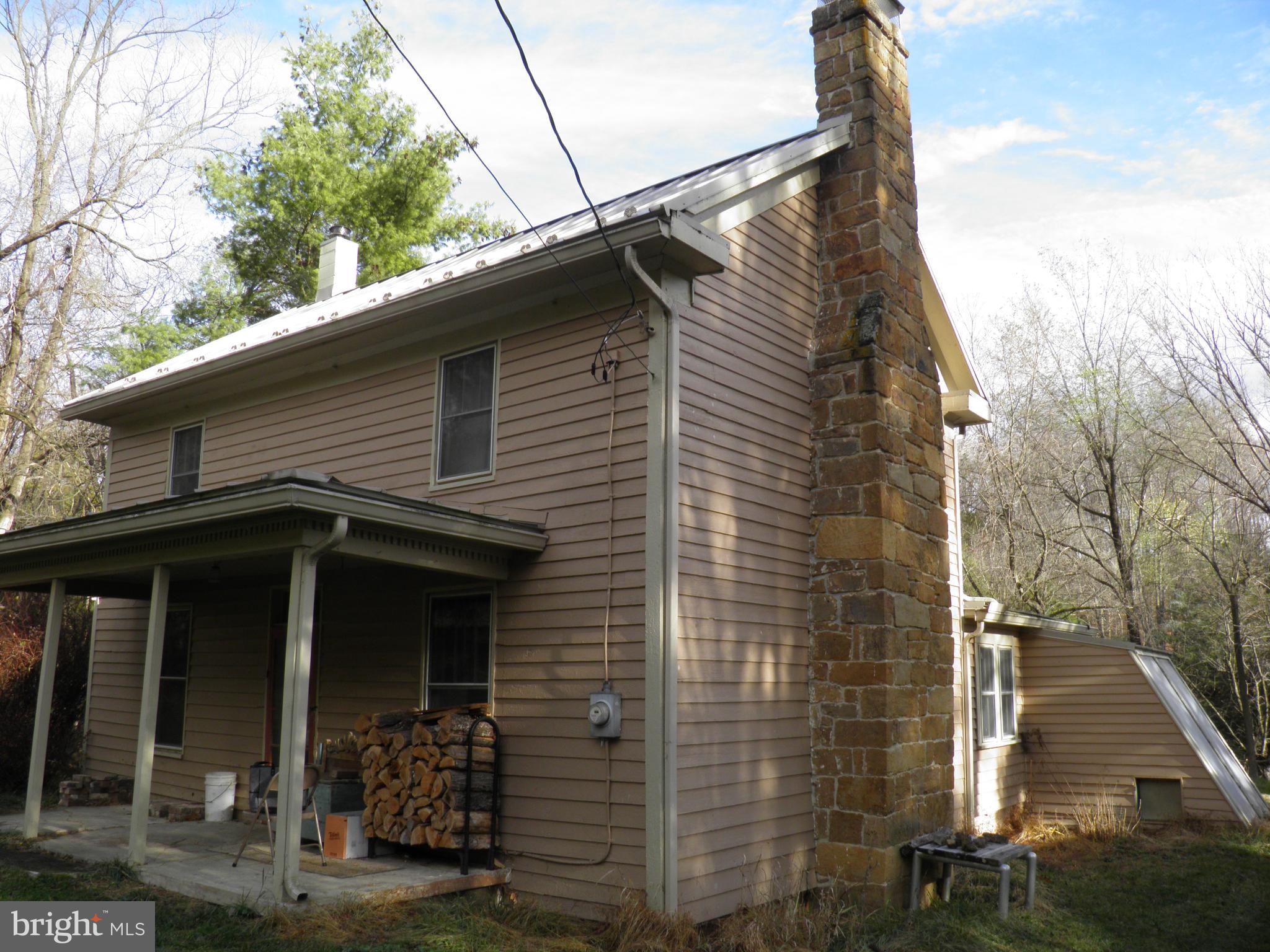 1,600 + square feet, 2 bedroom, 1 bath farmhouse- 2 outbuildings situated on 4.6 peaceful, unrestricted acres bordering a state maintained road. Original section of dwelling constructed in 1840 of hand-hewn logs. Public water plus 2 wells. Soapstone wood stove, propane, and EBB heat. New metal roof installed in 2018. Small greenhouse attached. Cell Service. Smoke Hole recreation area nearby. Ideal getaway or full time living.
