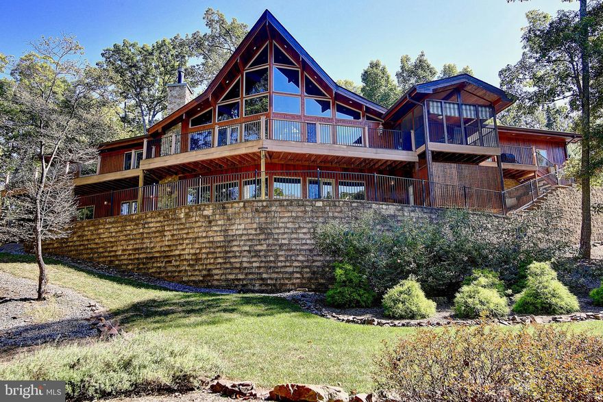 Stunning Chalet located in The Woods community boasts 4,400+ sq. ft. 4 Bedrooms, and 3 full Bathrooms. With just under 1 acre, this gorgeous Lindal Cedar home sits right on the golf course. Impressive cathedral ceilings, appealing exposed beams, and sleek hardwood floors make this open floor plan perfect for entertaining. Gourmet Kitchen with oversized island, high-end cabinetry, and double-oven for the baker in the family. The upstairs loft has a half bath and great space for playroom or office. Master Suite has high vaulted ceilings, tons of windows allowing natural light, an on-suite master bath with upgraded countertops and a large jacuzzi soaking tub. Lower level rec room has its own mini kitchen, 2 Bedrooms, Full Bathroom, and an exercise room. This home is a true beauty tucked away privately with its own "cabin-like" feel and stunning views