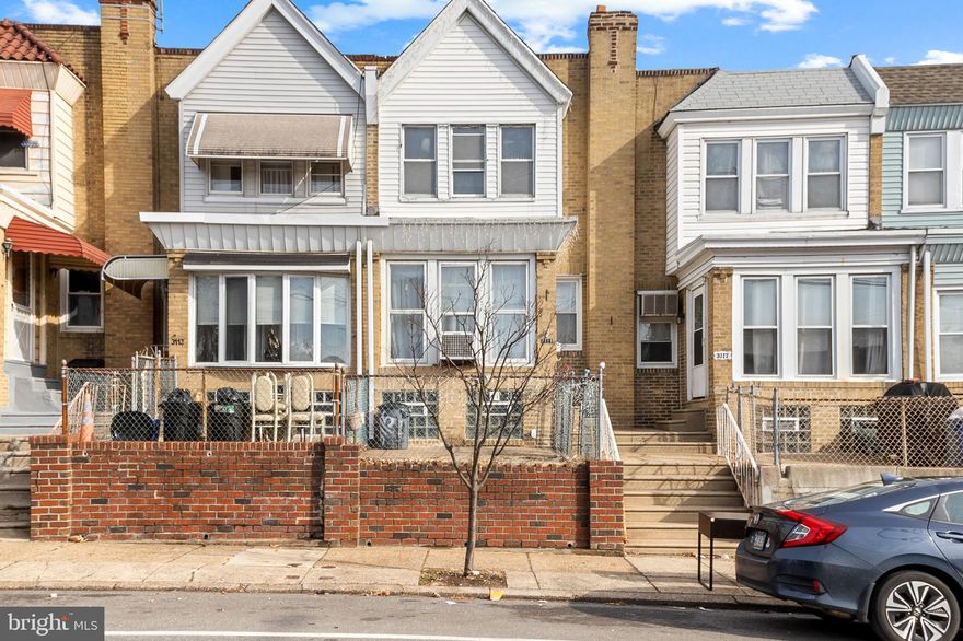 Welcome to 3115 Robbins Avenue, a charming straight-thru row/townhome nestled in the heart of NE Philly's vibrant Mayfair neighborhood. As you approach this classic starter home, you are greeted by a neatly fenced cement yard, a great spot for bbq, playing, or exercise. The enclosed front porch entrance, through the newer steel door, invites you to enjoy peaceful mornings with a cup of coffee or unwind in the evenings as the neighborhood comes to life with the friendly hum of community. Next, you find yourself in a cozy and bright living room, where a ceiling fan gently circulates the air and a faux fireplace mantle adds a touch of elegance. The space is perfect for gathering with loved ones or enjoying a quiet night in. Adjacent to the living room is the formal dining room, a space that beckons for shared meals and memorable conversations. The ceiling fan above ensures a comfortable ambiance, while the wood flooring throughout the home adds a seamless flow and a touch of warmth underfoot. The kitchen, equipped with a gas range/oven and exhaust hood, offers convenient flow and work space, along with an exit to the balcony that offers a breath of fresh air. Descend to the full storage basement, a canvas awaiting your personal touch. With the potential to be finished into additional living space, it currently houses gas utilities, a washer, dryer, and a full bathroom with a stall shower, and rear exit to the attached 1-car garage; providing practicality and convenience. The upper level of the home is a tranquil escape, featuring two well-appointed bedrooms, each with a ceiling fan for added comfort. The very spacious primary bedroom is a true retreat, offering ample space for relaxation and rejuvenation after a long day. Located just minutes from the Tacony Bridge into New Jersey, a short drive to I95 and Route 1, this home is a commuter's dream. Schools, public transportation, and the bustling Frankford Avenue Shopping Corridor are all within easy reach, ensuring that everything you need is at your fingertips. This versatile property would make a great home or a smart addition to an investment portfolio! Please take a minute to watch the Video Tour and then schedule your in-person walkthrough, today! Some photos have been virtually staged/enhanced.