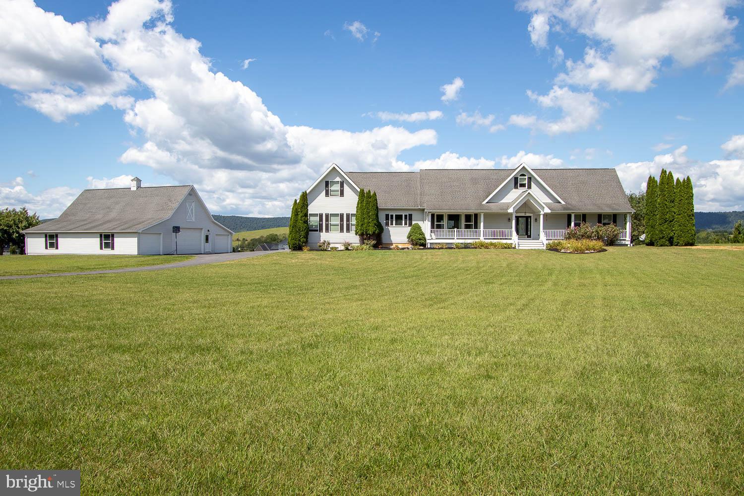 Just minutes from State College, this exceptional countryside retreat offers over 4,500 square feet of finished living space above grade and panoramic valley views on nearly 4 acres of gently rolling land. A dramatic wall of glass and vaulted ceilings flood the great room with natural light, creating a warm, expansive atmosphere. Step into the first-floor owner’s suite, complete with an ensuite bath and generous walk-in closet.
Enjoy year-round comfort with central air and recently upgraded radiant flooring powered by an HTP high-efficiency propane condensing boiler. A cozy fireplace anchors the main living space, while the finished lower level adds approximately 1,500 sq ft of versatile space, ideal for a home office, gym, or media room.
Out back, the expansive deck invites you to unwind and take in the stunning sunsets. The property also boasts a spacious 48×48′ detached garage/barn. Ideal for car enthusiasts or pursuing a variety of hobbies, providing versatile space to complement your lifestyle.