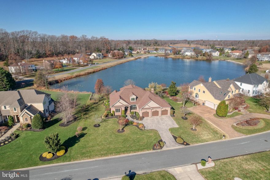Waterfront in the Caesar Rodney school district is available now! Every detail of this brick home, located in the most highly coveted Windswept neighborhood, has been crafted to showcase breathtaking pond views and luxurious living. From the moment you enter, walls of expansive Andersen windows frame the water, flooding each room with natural light and creating a serene backdrop that changes beautifully with the seasons. The home  flows seamlessly into elegant dining and living spaces, opening directly to a screened porch that feels like your private retreat—perfect for savoring morning coffee or evening wine while overlooking the water.
The gourmet kitchen is a chef’s dream, complete with upgraded appliances, a generous pantry, and a breakfast area designed to capture the view. An inviting family room with a striking gas fireplace with surround stone detail offers warmth and charm during cooler months. The main level also features a large office with custom built‑ins and skylights, laundry room, and an oversized three‑car garage with abundant storage. The luxurious primary suite is a true sanctuary, boasting a spa‑like bath with soaking tub, separate shower, and expansive walk‑in closets. An additional bedroom with attached full bath, and powder room complete the main floor.
Upstairs, two spacious bedrooms, a full bath, and a spacious loft  provide the perfect retreat for guests or family. Outdoors, the covered screened porch leads to a brick patio with a built‑in natural gas grill—ideal for weekend gatherings. The meticulously landscaped yard, enhanced by an irrigation system, frames the shimmering pond, where waterfowl, flowering trees, and summer reflections create a living masterpiece year‑round.
This home is not only stunning but also exceptionally well‑built, with premium features including a new roof,  new carpet throughout, gas‑fired generator, three‑zone HVAC, an encapsulated crawl space, and endless storage. Very rarely does a property combine such craftsmanship, location, and natural beauty.  Schedule your tour!