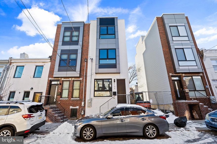 ** 7 years remaining on tax abatement** Modern Sophistication Meets Skyline Views in Dickinson Sq. Welcome to a masterpiece of modern design a brand-new contemporary residence offering 4 bedrooms, 3 luxury baths, and an effortless blend of style and functionality. Situated in one of Philadelphia’s most desirable enclaves, this home is designed for the discerning urban buyer. Enter into a sun-drenched, open-concept main level where wide-plank hardwood floors and high-hat recessed lighting guide you through the space. A striking architectural steel railing defines the staircase, adding an industrial-chic edge. At the heart of the home lies the chef’s kitchen, meticulously appointed with soft-close cabinetry, glistening quartz countertops, a custom backsplash, and a premium stainless steel appliance package. Just beyond the kitchen, glass doors open to your private rear yard a serene escape for morning coffee or intimate al fresco dining. Descend to the fully finished lower level, a versatile space ideal for a home theater, gym, or a private fourth bedroom complete with a full bath. The second level hosts two generously proportioned guest bedrooms awash in natural light, serviced by a beautifully tiled custom hall bath. The third floor is dedicated entirely to the owner’s retreat. This primary suite features a sprawling walk-in closet and a spa-inspired bathroom boasting dual vanities and designer fixtures. Finally, ascend to the crown jewel of the home: an expansive rooftop deck. Offering breathtaking panoramic city views, this is the ultimate setting for sunset cocktails and entertaining. With upper-level laundry and high-efficiency HVAC, this home checks every box.