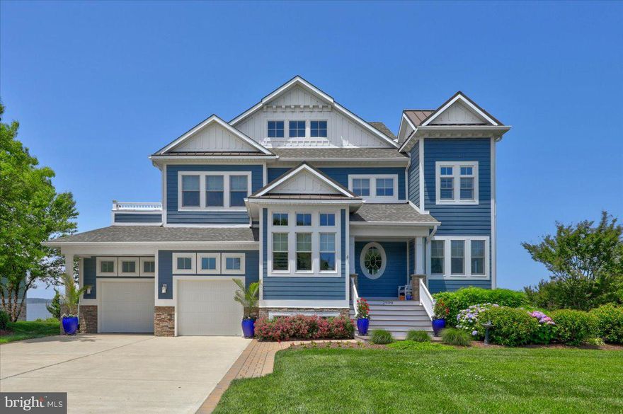 Exceptional Bayfront home with 120 feet of direct water frontage, including a private dock with 2 boat lifts and a sandy beach along the shoreline! This stunning custom built home was crafted with fine finishes and features and was expertly designed to take full advantage of sweeping bay views on every level. The main living level features a spacious open floor plan with an impressive great room that opens to a large waterfront screened porch and deck, creating the ideal layout for entertaining. The kitchen is a chef's dream with top of the line cabinetry and countertops, gas range with hood vent, subway tile backsplash, and large center island with seating. Upstairs the expansive primary suite features a private waterfront deck, beautiful spa-like bathroom and a sitting area. There are 3 additional spacious bedrooms and 2 full baths on this floor. The ground level offers a large additional family room with a pool table, 5th bedroom, large office that can double as additional sleeping space, laundry room and a full bathroom. Step outside to the covered patios complete with a hot tub and enjoy evenings around the hardscaped fireplace at the waters edge. Offered with designer furnishings this home is ready to be enjoyed. Situated on a quiet non-thru street, this is the perfect location, only 6 miles to the beach yet tucked away from the crowds.