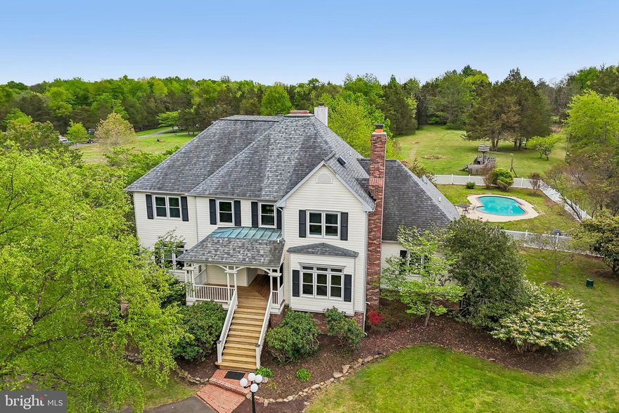 Magnificent residence set on 10 private acres, on the Gainesville end of Nokesville offering true main-level living, pond access, and a private swimming pool—creating an exceptional retreat. Upon arrival, you will appreciate the ample parking, along with a fully finished studio attached to the detached garage, complete with its own full bathroom and kitchen. 

Inside, the main level features beautiful hardwood flooring, a formal dining room, and a dramatic two-story family room with a wood-burning insert, direct access to the deck, and kitchen. The updated kitchen is thoughtfully designed with new quartz countertops, stainless steel appliances, white cabinetry, tile flooring, a butler’s pantry, and an expansive walk-in pantry. From the kitchen, you have very convenient access to the mudroom and attached two-car garage. 

The main-level primary suite offers deck access and views of the pool.  The fully renovated en-suite bath showcases heated floors, a double vanity with exotic granite, a clawfoot soaking tub, an oversized glass-enclosed shower, and a spacious walk-in closet with custom built-ins. The main level is complete with an additional living room and a powder room.

The upper level offers four additional bedrooms, two full bathrooms, and a fourth-level loft—an impressive and versatile flex space that is a must-see. One of the bedrooms features a gas log insert, providing added warmth and ambiance during the colder months. This level also offers plenty of additional storage opportunities as well.

The fully finished basement features luxury vinyl plank flooring throughout, a full bathroom, and a walk-out exit to the rear yard. The spacious layout is ideal for entertaining while also offering plenty of additional storage options.

The detached garage and fully finished 2 level studio is a must see! The garage has 4 parking spaces and private access to the studio which offers 1.5 baths, washer, dryer, kitchen area, and open flex space. Upstairs would make a perfect game room or art room.  The studio has it's own electric meter and heating/cooling.

Notable updates include a 50-year architectural shingle roof (approximately 7–8 years old), whole house generator, newer windows throughout, a water treatment system, newer well pump, holding tank, and a whole-house generator. A hot tub hookup is conveniently located near the deck. The pool has been recently renovated and is ready for summer enjoyment!