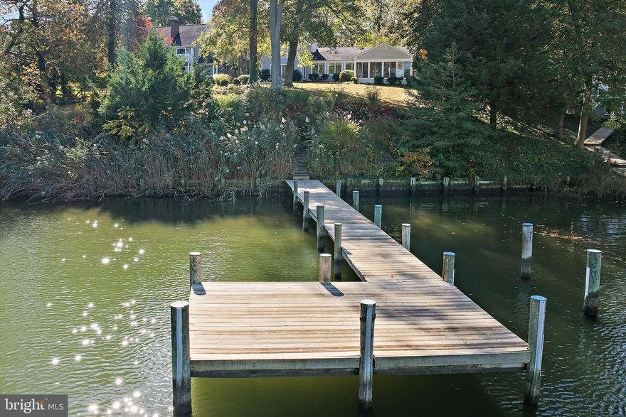 This fantastic property with over 100 feet of waterfrontage is ideally located on a protected cove minutes from the Severn River and the Chesapeake Bay.  The .69 acre property boasts lovely views from Lake Ogleton to the Bay Bridge from its perfect perch on a gentle sloping hill.  The shoreline is bulkheaded and there is a private pier with good water depth and lots of great dockage for all your watercraft.  The original structure was one of the first in the neighborhood and has a two-story addition with a large kitchen and primary suite. The original house features spectacular views, charming living and dining rooms, two main-level bedrooms, and a fabulous sunroom.  The expansive kitchen opens to the waterfront family room and has plenty of room for entertaining.  On the private 2nd level, there are sweeping waterviews, a huge primary bath, ample closets and a sitting area. The house, safely located outside of flood plains, is currently not in the HOA.  The new owner may choose to join the HOA for a reasonable fee. Community offers a marina, waterfront parks and more.