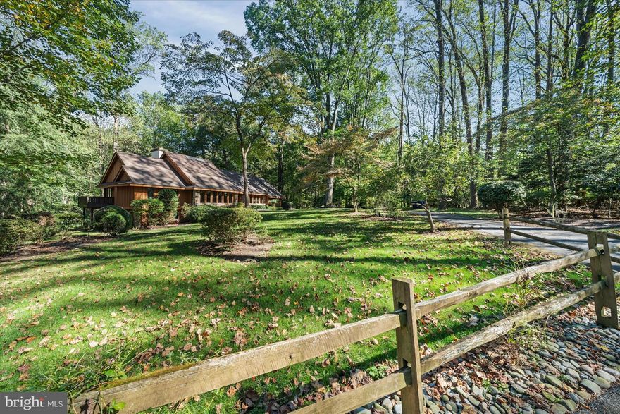 Nestled in the exclusive community of Quail Crossing, this exceptional custom-built contemporary residence is the first home completed in the neighborhood—crafted by renowned designers Hillcrest Associates and built by the esteemed John Lester Builders. Offering over 4,100 square feet of meticulously designed living space, this one-of-a-kind home is privately situated on a quiet, winding tree lined street, just a short walk to Centreville, with its charming shops and restaurants, and minutes from Greenville. This two-story architectural gem features three bedrooms, three and a half bathrooms, and stunning views from every room. The moment you step into the expansive, light-filled foyer—with its soaring ceilings and skylights—you are greeted by an open-concept layout that seamlessly connects formal and informal living spaces. Dramatic cathedral ceilings and walls of windows create a bright and airy atmosphere throughout the main level. The elegant foyer is flanked by a formal dining room on one side and a living room on the other, both offering beautiful natural light and scenic views. A striking floor-to-ceiling stone fireplace serves as the centerpiece of the cozy family room, while a stylish wet bar connects the space to the heart of the home: the kitchen. Updated with granite countertops, a large island with bar seating, and ample room for casual dining, the kitchen is both functional and welcoming—perfect for everyday living or entertaining. Adjacent to the kitchen, a screened-in porch invites you to enjoy alfresco dining surrounded by nature. Additional main level features include a powder room, laundry room, and access to the expansive rear deck that wraps around the home, offering tranquil views of the wooded backyard. Upstairs, the luxurious primary suite offers a private retreat with its own balcony, dual ensuite bathrooms, and two oversized custom walk-in closets—providing both comfort and convenience at every turn. The lower level adds tremendous versatility with two spacious bedrooms that share a full bathroom, along with a dedicated office featuring custom built-in wood cabinetry and a matching desk. This space also functions as a fourth bedroom, thanks to a custom-designed Murphy bed. Thoughtfully designed, impeccably maintained, and set in an ideal location, this remarkable home is ready for its next owner to move in and make it their own. Whether you're seeking quiet retreat or an entertainer’s dream, this property offers the perfect canvas to personalize and enjoy for years to come.