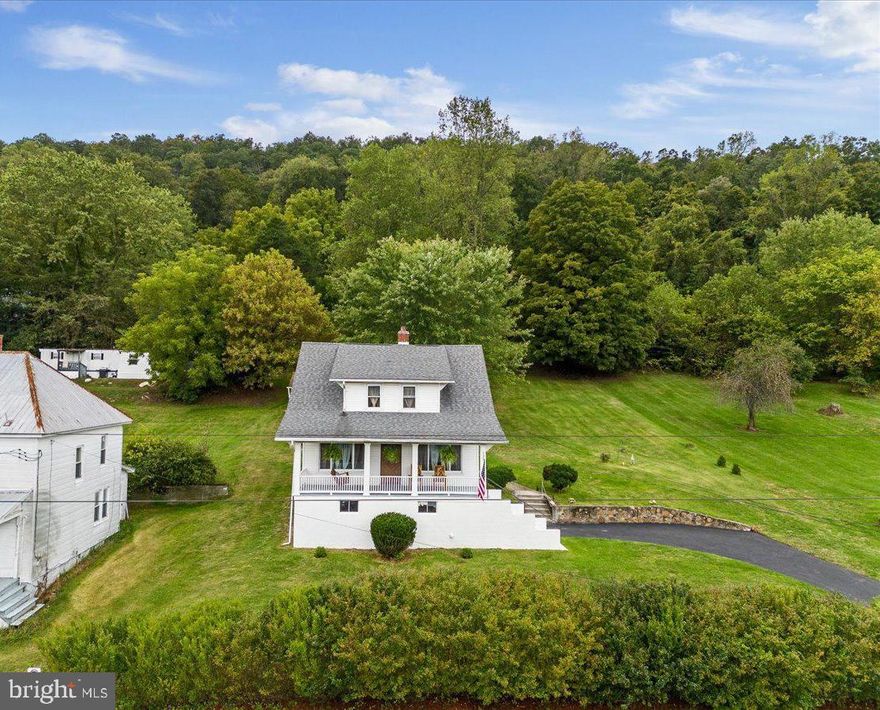 Welcome to this charming, meticulously maintained 1930’s colonial located outside the corporate limits of The Ole Town of Bath (Berkeley Springs.)  Close to town amenities and schools, yet feels secluded and tucked up on the hill with a wonderful view of the mountain from the extra deep covered front porch (with a hanging porch swing!)  Entering this home you will enjoy the old world charm that makes this a wonderful place to call home.  Beautiful hardwood floors run throughout the main level with the country kitchen tucked between the spacious family room and the dining room which sports pocket doors.  Climbing the wide, elegant staircase to the second level you will find brand new carpeting for the three bedrooms, of which two of them have walk in closets.  The one full bath is located on this level as well and has a tub/shower combo, along with a wall of storage drawers.  Out back there is a covered patio for entertaining and three outbuildings, two of which have electric.  Architectural shingle roof is 2017 and this property is two separate lots with an easement for access to the second lot which can be built on, or enjoy the extremely large backyard with its mature landscaping.  All contents can convey with an acceptable offer.  This home has been in the same family for over 60 years and they lovingly kept it in pristine condition.