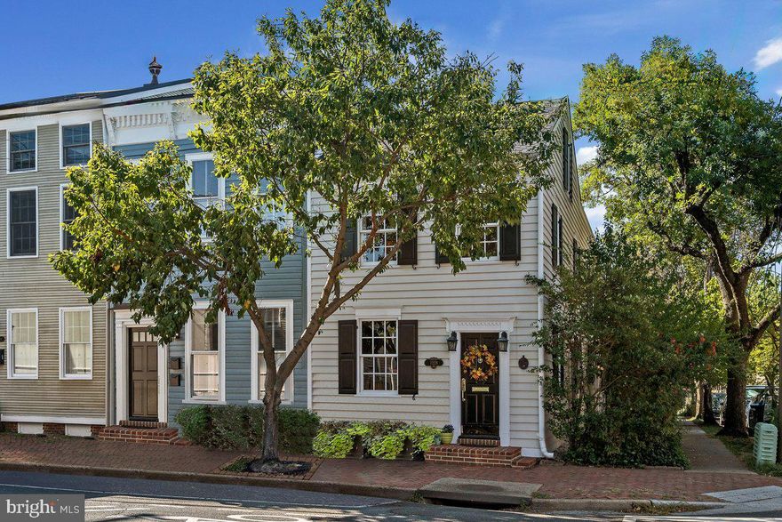 Welcome to 1228 Prince Street, your dream home in Old Town Alexandria!
Just minutes from Washington, DC, this delightful home is superbly located in the
heart of Old Town, a short walk to the King Street metro, steps from Whole Foods,
restaurants, shops, spas, a short walk to the Potomac River waterfront and biking trails,
12-minutes from DCA airport, and quick access to the 95/495 and local bridges.
Zoned for limited commercial use, this quaint 3 to 4-bedroom townhome with 2.5
baths exudes timeless elegance, a quintessential piece of Alexandria 's rich history
updated in a way that preserves its heritage. You 'll be captivated by the picturesque
facade adorned with black wooden shutters and inviting flower boxes bursting with
vibrantly colored blooms. Upon approaching the side entrance, you’ll pass under a white
wooden arch gracefully framed with climbing white roses and purple clematis. This
delightful feature adds an architectural focal point while providing a warm and inviting
welcome to all who enter. As you walk through the pergola, you’ll be enveloped by the
scents of flora filtered by sunlight, making you feel as if you’re about to enter a secret
space.
Stepping inside, you will be greeted with the perfect blend of historic charm and
intimate modern comfort. The home retains its classic character, featuring hardwood
floors, and an original 200-year-old hardwood handrailing, and 4 mantled fireplaces.
You'll find contemporary amenities including gourmet kitchen appliances and built-in
shelves to ensure a comfortable Old Town lifestyle with ample storage. The home has
three staircases, one leading from the first floor to the second, another from the second
floor upward to an attic bedroom/office and the third from the first floor downward to a
finished office/bonus space with laundry and utility areas and built-in shelves.
The intimate family room leads to a protected brick terrace overlooking a private
fenced-in garden full of flowering perennials, a serene and tranquil escape from the
hustle of the outside world. Relax and unwind in your private oasis as you watch the
birds and enjoy a view of the canopy of mature wisteria embracing the large wooden
pergola shading the garden or enjoy the built-in stone grill and outdoor seating for al
fresco dining. This captivating outdoor retreat beckons you to relax and unwind
surrounded by the sights and sounds of nature. The garden gate opens to a private
parking space outfitted with an electric vehicle (EV) hookup and a storage shed for
bikes and gardening supplies.
As you enter the guest bath on the second floor, you'll find a charming antique
clawfoot tub adds a touch of nostalgia to the home. In the master bedroom, you'll
discover the modern indulgence of a soaking tub where you can end your day enjoying
a relaxing bath with the French doors open to a private treetop terrace where you can
bask in the sun, savor a good book, or simply relish a different perspective of the
historic neighborhood.
Don't miss the chance to create lasting memories in this piece of living history, a
sanctuary of comfort, and an embodiment of the Old Town's timeless allure.