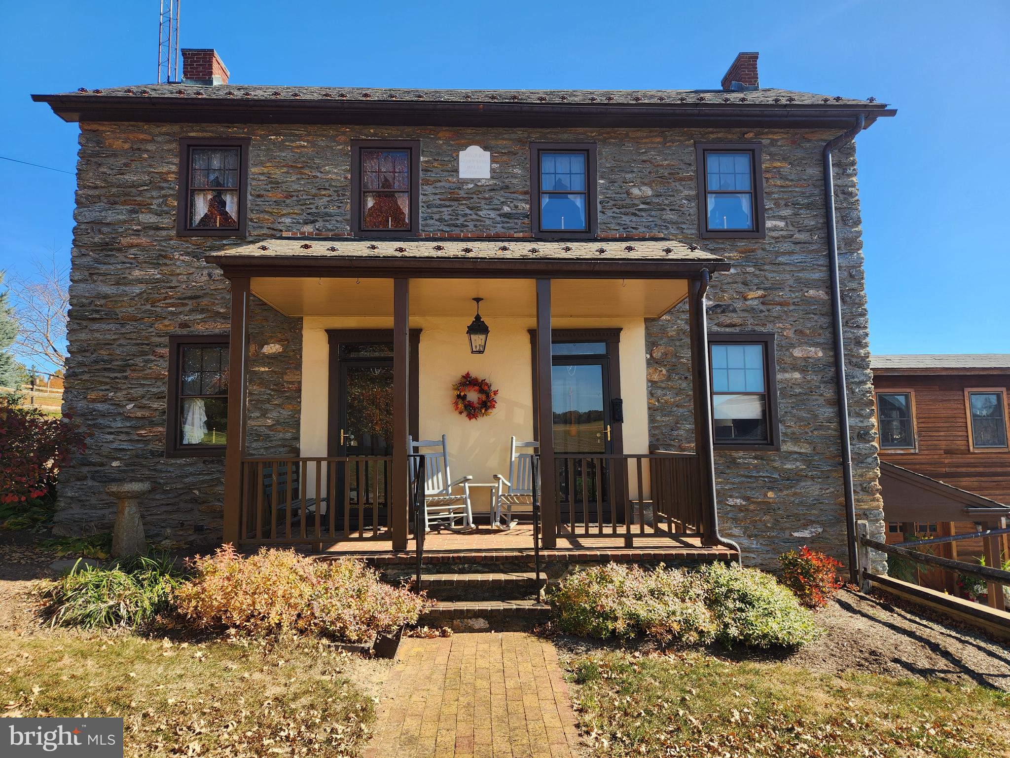 This property will be offered at Public Auction on Monday, December 16, 2024 @ 1pm. The listing price is the opening bid only and in no way reflects the final sale price. $150,000 down due at auction, 2% transfer tax to be paid by the purchaser, real estate taxes prorated. This picturesque 52-acre farm is perfectly secluded yet conveniently located just minutes from Routes 272 and 372. Tucked away from the main road, this property is situated in the heart of the thriving Lancaster farming community.
The home, originally built in the 1700s and expanded in the 1800s and 1992, has been beautifully restored and meticulously maintained inside and out. The first floor features two spacious, flexible areas currently used as a large office and a formal living room with a fireplace, a single bedroom, and the 1800s kitchen with a fireplace. This level flows into the 1992 addition, which includes a modern kitchen, a full bathroom, and a dedicated laundry space. Upstairs, the second floor offers three bedrooms and another full bathroom. The lower level boasts the original 1700s kitchen, complete with a walk-in fireplace and brick floors, alongside a full basement with brick and stone walls, along with an oversized two-car garage underneath the 1992 section of the home. Additional structures on the property include a 2-story bank barn built in 2020, designed for cattle on the lower level and storage above, as well as a beautifully appointed 2-story carriage house built in 2013, featuring three horse stalls and three equipment bays. The carriage house also includes stairs leading to hay and straw storage and boasts attractive board and batten siding. There’s also a spacious wood shop and storage building, perfect for all your needs. This property features 35 acres of tillable land, an 8-acre fully fenced pasture with a continuously flowing stream that supplies water to a 1000-gallon underground storage tank and watering trough, and the remainder is wooded. This property is in Clean & Green but is not preserved.