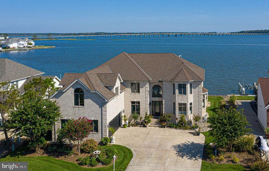 Spectacular One-of-a Kind Custom Built Direct Bayfront residence.  Savor the unobstructed views of the Isle of Wight Bay, Ocean City Skyline & the Rt. 90 Bridge.  Your watercraft will be at your immediate beck and call just steps from the spacious rear deck!  There is 90' of bulkhead, replaced in 2019, a private pier,  9,000 pound Boat Lift with remote, water and electric, and also a permit for a jet ski lift.  This home welcomes you into the 2 story foyer through the leaded glass door and custom marble tiled floor.  Hardwood Floors, Ceramic Tile, and Andersen Casement windows and doors are found throughout.  The formal Dining Room features a striking architectural ceiling, built-in cabinetry, and a Viking Wine Cooler.  You will enjoy cooking in this Gourmet Kitchen highlighted with Top-of-the-Line Cabinetry, Granite Counter Tops, Extra-Large Island with prep sink, breakfast bar, and Commercial Quality Viking Stainless Steel appliances.  The adjacent Family Room and Living Room boast window walls showing off the expansive water views, and a 2 sided floor to ceiling Stone Fireplace with Granite Base.  One of the Primary Bedrooms is located on the 1st level, with another striking ceiling and wall of windows, an oversized 6' whirlpool tub, tiled & polished stone separate shower with 8 jets and 3 shower heads.  The home's central focus is the beautiful custom curved stairway with wrought iron accent railing.  On the 2nd level you will find 3 more bedrooms (one with a private balcony), 3 full baths, an office, and a "Bridge" overlooking the entry and living areas.  A 2nd set of stairs leads to a  huge Game Room, complete with Vaulted Ceiling, Pool Table and Granite 7 ' Bar equipped with cabinets, bar sink and under-counter refrigerator.  From here, a 3rd stairway leads to the unfinished attic, a 10x20 area that could add more square footage if needed.  All of the features of this special home are too numerous to mention, but are  outlined separately for any potential purchasers.