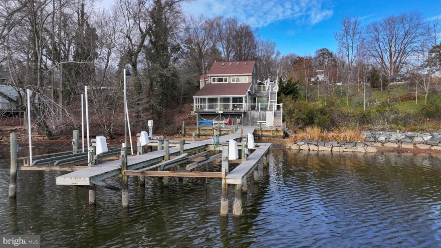 Waterfront retreat on Long Cove (off Stoney Creek) featuring a pier, boat lifts, and approximately 4' MLW depth!  811 North Long Cove Road offers 3-4 bedrooms spanning 3-levels, a recently renovated eat-in kitchen with island and new LVP flooring that continues into the spacious family room. The family room features a vaulted ceiling, gas stove, and multiple sliding doors opening to a 22' x 8' covered waterside deck—perfect for entertaining and enjoying the views. The kitchen level includes one bedroom and a full bathroom. The main level offers two additional bedrooms and a full bathroom, while the upper level provides a fourth bedroom or flexible bonus space. Additional highlights include 3 decks (in addition to the covered porch), a separate laundry room with front-loading washer and dryer, 17 1/2' x 23 ' detached garage with electric and garage door opener, storage shed, side deck with retractable awning, and tiered exterior stairs leading to the water. A level green space sits just steps from the private parking pad, offering both convenience and privacy. Roof, siding, and gutters replaced in 2019.  New kitchen cabinets, granite countertop, dishwasher, sump pump & vapor barrier in crawl space in 2025.  Room measurements rounded up or down accordingly.