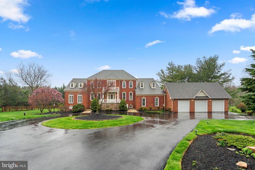 An incredible 5,670 sqft manor residence sited on a 3.07 acre homesite with a circular drive approach on a quiet cul-de-sac in Highland Meadow merges elegance and modern craftsmanship featuring a handsome brick front exterior with dual stairs to a front porch, upgrades throughout, and abundant natural light. Offering countless amenities this home is thoughtfully planned with entertainment and casual areas found throughout this residence featuring elegant touches and comfort, a gym on the main level, vaulted ceilings, large profile crown moldings, wainscoting,  and an architectural distinctiveness with rich angles. A warm welcome awaits when you cross the threshold of this luxury home embodied with elegance and featuring a two-story foyer accented by a Palladian window waterfall staircase and a second level overlook, enriched hardwoods, tray ceilings, and an array of windows with cascades of natural light filling each room with brightness and warmth. Spectacular design throughout the three levels offers plenty of recreational and casual rooms no matter what is in your wheel house. Surrounded by expert landscaping and located in one of Howard County’s most desired communities, this relaxing retreat delivers an ideal location for commuting to the Baltimore and Washington metro areas, dining, shopping, golf courses, country clubs, entertainment, and airports. A foyer entry introduces this home featuring a spacious formal living room with heightened windows and profile crown molding, French doors opening to a study with built-ins, a formal well-trimmed dining room accentuated by wainscoting and a ceiling medallion ready for celebratory diners or small intimate gatherings. Entertaining space continues in a rejuvenating sunroom or conservatory showing ceramic tile flooring, an angled ceiling, and a full surround of Palladian windows with custom louvre blinds, and a gorgeous two-story family room with a raised hearth fireplace, stunning detailed trim work and mantle, a second floor overlook, plus a main level gym that sits halfway between the main and lower level with a walkout to the yard. Prepare chef inspired meals in the richly appointed gourmet kitchen boasting track lighting, ceramic tile flooring, 42” raised panel espresso cabinetry, granite counters, complementing tile backsplash with a diagonal design, a breakfast bar with pendant lighting, stainless steel appliances, a center island with a downdraft cooktop and a breakfast room with a walkout to a tiered low maintenance deck spanning the rear of this home with private thick tree-lined views. The upper level hosts 4 bedrooms including the owner’s suite presenting a sitting room, a loft overlooking a sunroom,  a walk-in closet, and a luxe bath offering dual vanities with a dressing table in the center, a custom shower, and a soothing platform soaking tub. Spend countless hours in the expansive lower level ready for relaxing and movie nights boasting a rec room, a game room, a custom bar area adjacent to a sitting space or dance floor with an ambient fireplace a bedroom, a full bath, additional storage space, and a walkout to lower sunroom accessing the paver patios and backyard with a covered shade structure picnic area. Providing an outdoor entertainment venue where you can enjoy relaxing evenings watching the sunset is a low maintenance deck, a lower patio with custom lighting, and a professionally landscaped gorgeous green lawn. Experience this hallmark home in a notable Howard County location with beautiful surroundings and a promise of fantastic new memories!