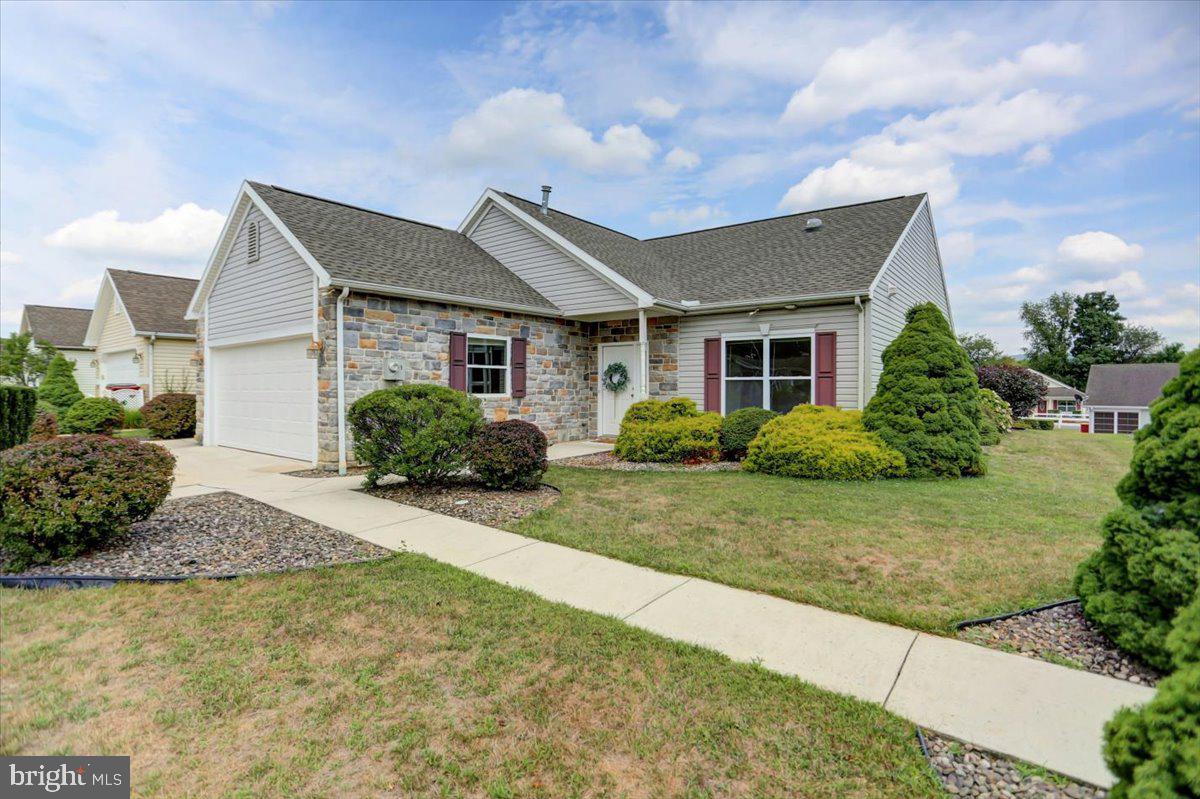 Back on the market - the prior Buyer did not receive community approval - this is your chance! This updated Windsor model home is situated in the gated 55+ Country Manor community, offering a secure and tranquil lifestyle. It features an inviting three-bedroom, two-bathroom layout spanning approximately 1,998 square feet. The open floor plan features 9-foot ceilings, creating a warm and spacious atmosphere. The kitchen boasts a large, angled island with bar seating, providing ample meal preparation and gathering space. Nearby, the bright dining area is an ideal spot to enjoy meals. The light and inviting sunroom, featuring a vaulted ceiling and tall windows, beckons you to relax by the charming gas stove. Step outside to enjoy the expansive backyard patio, perfect for BBQs and al fresco dining. The primary bedroom showcases a tray ceiling and an en-suite bathroom with a dual-sink vanity, separate water closet, generous walk-in closet, and a large walk-in shower. The home's laundry room, located off the kitchen, includes a utility sink and direct access to the climate controlled two-car garage. Cleaning is a breeze with the built-in central vacuum. This home has recently been updated with a new roof, luxury vinyl plank floors and fresh paint throughout, new garage door and opener, new back patio door and the list goes on! The home is economically heated with a natural gas forced hot air furnace (8yrs old) and cooled with central air conditioning. Residents can take advantage of the community's extensive amenities, including a tastefully appointed clubhouse with a large gathering room, full kitchen, cozy gas fireplace, library and for an additional fee, a fitness room. Additional community features encompass a screened-in gazebo overlooking the mountain and a stocked fishing pond with a fountain, as well as yard games and walking trails. This exclusive lifestyle comes with a monthly fee of $633 which covers sewer, trash, and recycling services, providing convenience and peace of mind. Your full ownership of the home includes a 29-year renewable land lease for your lot. Pets are welcome, with a limit of two per household. The home's convenient location provides easy access to a variety of shopping, dining, entertainment, golf, and medical options, as well as major highways. This well-appointed residence presents an opportunity to embrace a comfortable and carefree lifestyle. Purchase is contingent upon Community Approval.