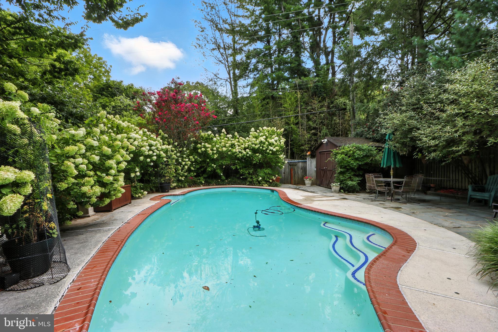SWIMMING POOL PARADISE IN MT WASHINGTON***Surrounded by a sea of blooming white hydrangeas, this quintessential Mt Washington gem sits on a picturesque, winding, tree lined street. Step through a charming wooden picket fence and you'll be greeted by lush perennial gardens featuring pachysandra, hostas, Japanese maples, crape myrtles, oak leaf hydrandeas, fig tree, helleborus, river birch, and more. A welcoming covered front porch, anchored by two custom benches, invites you inside. The formal living room boasts built-in bookcases, a cozy fireplace and a charming built-in bench. The spacious formal dining room is lined with custom cabinetry, while the stainless-steel kitchen is a cook's delight complete with abundant storage, a built-in banquette and thoughtful built-ins throughout. Two entry level bedrooms share a full bath, while the private second floor hosts a third bedroom with built-in bookcases and a wood burning stove. The finished lower level offers a powder room, utility room, generous storage and a walk-out to the back yard oasis. Out back, the fully fenced and private yard features the show stopping Anthony in-ground pool with slate patio, all surrounded by vibrant hydrangeas. Two Storage sheds and an outdoor storage box add convenience. Being sold "as is", with inspections welcome for informational purposes only. No known defects-just a truly special home ready for its next chapter.
