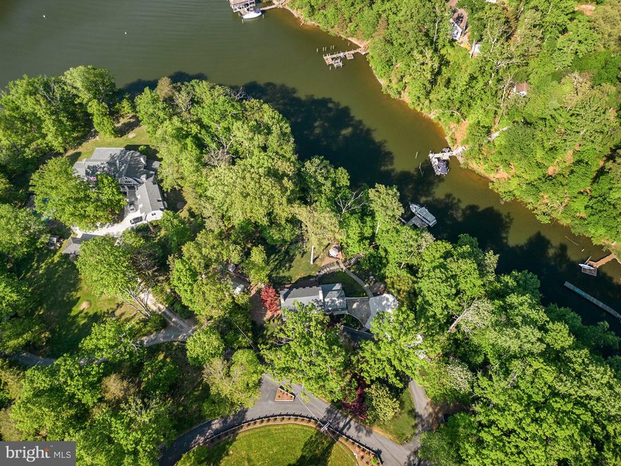 Private waterfront retreat...Enjoy wonderful water views of Luce Creek throughout the home. Located on nearly two serene acres just minutes from Downtown Annapolis, private waterfront estates like this do not come along often. Completely renovated from top to bottom, this gorgeous home maintains original character and charm with all the modern conveniences of luxury living.  From the welcoming & wide front porch perfect for porch to the open concept main level maximizing every waterside view- you will love each thoughtful update allowing you to escape the busy world and relax in your own personal retreat.  Designer lighting, custom wall paper and neutral paint, charming dutch doors, farmhouse black Andersen windows, gorgeous hardwood floors plus a gourmet kitchen fit for a chef with white marble backsplash, quartz counters & white shaker cabinets and a large 5+ person center island.  Entertain with family and friends hosting your favorite holiday in the large dining room with charming fireplace serving as a focal point.  Bring the guests outside to enjoy the beautiful gardens. Host summer barbecues on the large deck overlooking the water, sip cocktails on the private screened porch & enjoy evenings overlooking Luce Creek by your firepit.   Bring your boat to the private dock  for endless memories along the shores of the Severn River.  Lush landscaping and hardscaping all along the property.  The upper level is expansive, featuring 4 bedrooms, 2 full baths plus the laundry room. A third fireplace offers a cozy ambiance in the primary suite.  Both full bathrooms boast complete renovations with quartz counter tops, gorgeous Carrara flooring and new fixtures and lighting.  Travel to the lower level with a full basement offering garage access, and bonus rec space used as home gym, office and additional living area with ample storage and a rough in for an additional bathroom.  2 car side entry garage parking with plenty of additional driveway space. Home also features newer water treatment system, newer HVAC and updated electric and plumbing.  Easy commuter access & close to shopping, dining & entertainment- this one will not last long. Schedule your private tour today!