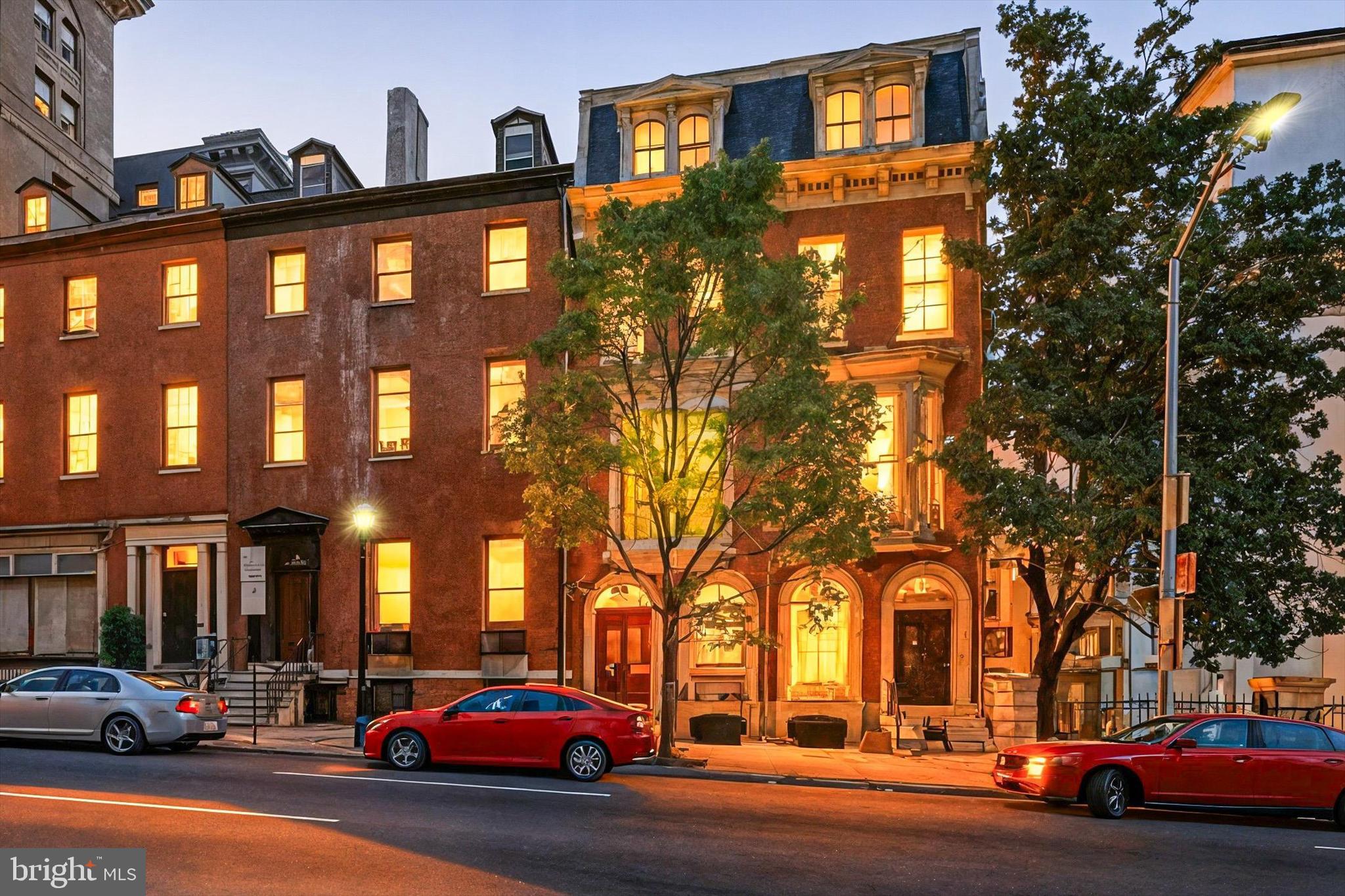 Welcome to 16 W Franklin Street, where historic elegance meets modern convenience in the heart of Mount Vernon. This striking Second Empire townhouse has been thoughtfully restored to blend original character with updated systems for comfortable living.
Inside, you’ll find exquisite period details including ornate mantels, intricate plasterwork, a dramatic skylit staircase, and rare zebra-striped wood floors. The main level offers a welcoming parlor, formal dining room with bay window, and a full guest bath.
Upstairs, the grand living room boasts 12-foot ceilings, a marble mantel, and original mirrors, alongside a powder room and spacious eat-in kitchen ideal for entertaining. The third floor hosts two bedrooms and a full bath, while the top level is devoted to a private primary suite with spa-like bath, steam shower, double vanities, dressing room, and laundry.
The unfinished basement with front and rear entrances provides storage, workshop space, or creative flex use. A private carport with garage door accommodates up to four cars in tandem, a rare city convenience.
With updated electric and plumbing, cozy gas radiator heat, and dual-zone high-efficiency central A/C, this home is as comfortable as it is captivating. Perfectly positioned between the Basilica and the Walters Art Museum, this is a rare opportunity to own a piece of Baltimore history.