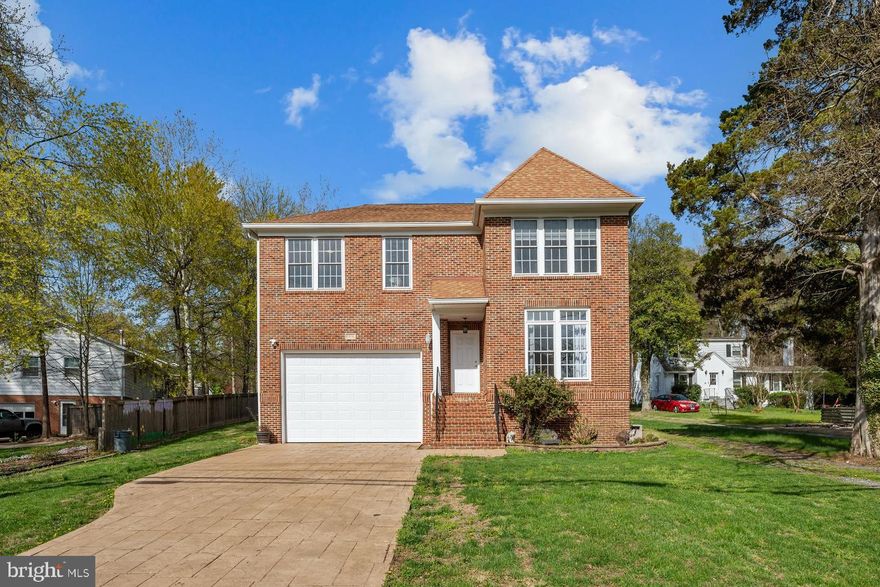 Welcome home to Annandale, where classic brick-front curb appeal, a professionally appointed chef's kitchen, and an extraordinary detached barn garage come together on a sprawling, mature-tree-lined lot to offer a lifestyle that is truly difficult to replicate. The main level greets you with hardwood flooring flowing through the formal living and dining rooms, both featuring tray ceilings with crown molding and elegant arched doorways - the dining room anchors the space with a statement lantern chandelier and generous natural light from oversized windows, while the formal living room offers a bright and serene retreat just off the entry. The chef's kitchen is a showstopper, appointed with custom natural wood cabinetry with glass-front uppers, dramatic black granite countertops, a massive center island with bar seating, a pot filler faucet, a professional-grade Thermador multi-burner stainless range with commercial-grade hood, stainless refrigerator, a built-in desk nook, and tile flooring that flows seamlessly into the generously sized family room - complete with a corner tile-surround fireplace, ceiling fan, crown molding, a sweeping wall of windows overlooking the backyard, and French doors opening directly to the yard. Upstairs, hardwood flooring continues through the open landing with its classic wood banister and pendant lighting, and into multiple generously sized bedrooms - one features its own custom built-in closet system with dedicated hanging, shelving, and drawer space, and a well-appointed hall bath with a double quartz vanity and tile tub/shower serves the level beautifully. The expansive primary suite is a true sanctuary, featuring plush carpet, serene backyard views from multiple windows, a private wet bar, a private upper-level stacked laundry closet, and access to two stunning custom walk-in closets outfitted floor-to-ceiling with built-in drawers, hanging rods, dedicated shoe shelving, and a vanity with mirror - the spa-inspired primary bath completes the retreat with a soaking jetted tub, frameless glass walk-in shower, dual vanities, and tile flooring throughout. A beautifully finished third bath with an ornate wood vanity and glass walk-in shower with bench and tile flooring adds further flexibility for guests or additional bedrooms. The lower level offers incredible potential and is ready for your personal touch - with a roughed-in bath with an ornate vanity already in place, a dedicated workshop and hobby room with built-in cabinetry, shelving, and concrete flooring, and expansive open space awaiting your vision, whether that be a recreation room, home theater, gym, or in-law suite. Outside, the fully fenced rear yard offers a level lawn, French door access from the kitchen, new raised garden beds in progress, and a long paved lane leading to the crown jewel of this property - a two-story detached barn-style garage featuring two vehicle bays and a massive framed-and-floored loft above with soaring ceilings, ready to become a studio, workshop, home office, or creative retreat unlike anything else in the area. Zoned for Columbia Elementary, Poe Middle, and Annandale High School in Fairfax County Public Schools. Just minutes to Heritage Shopping Center, Mosaic District, Inova Fairfax Hospital, Northern Virginia Community College, and Annandale's renowned dining along Little River Turnpike. Quick access to I-495, I-66, and the Dunn Loring Metro. Schedule your private tour today - this one will not last!