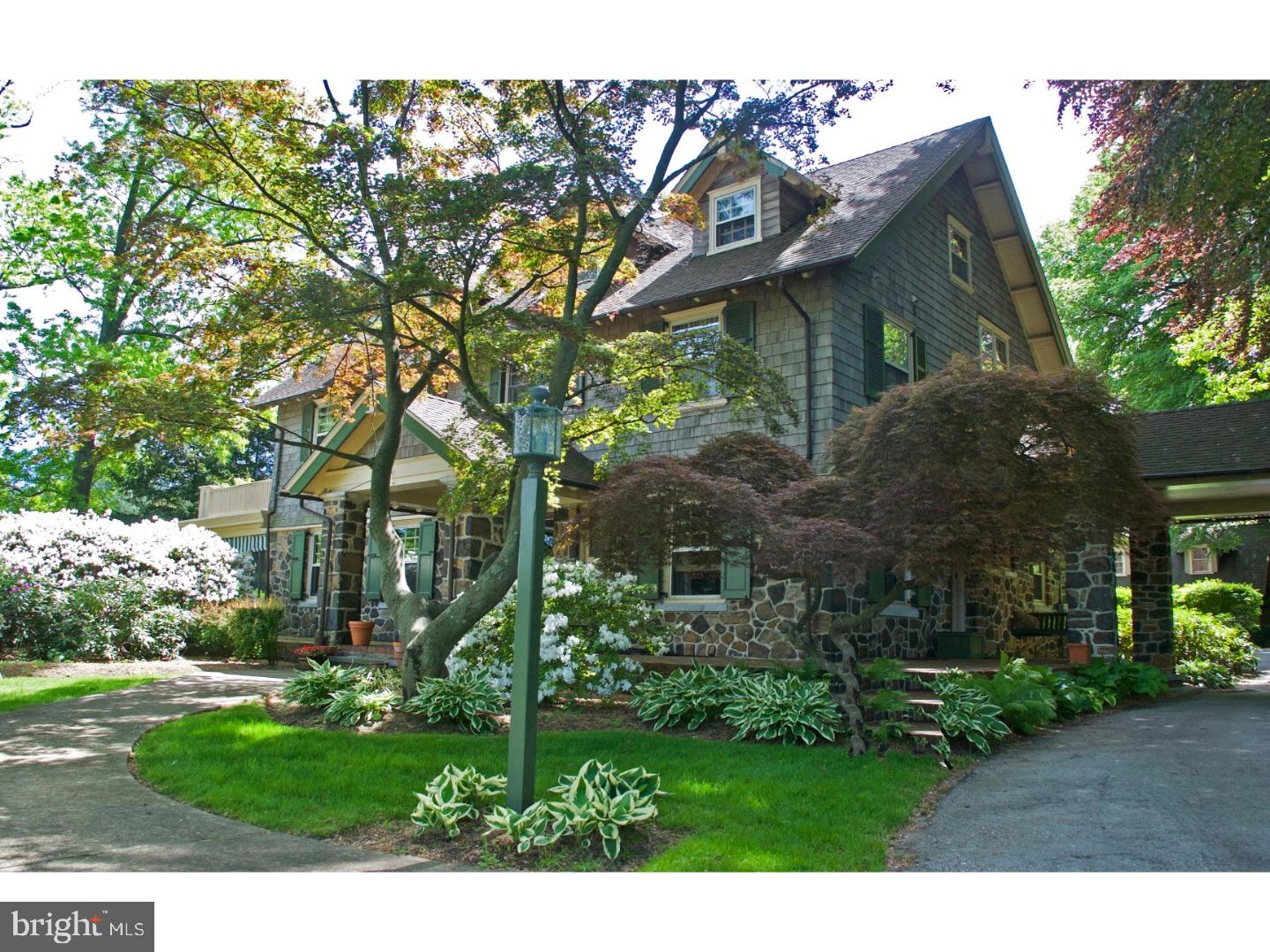 This classic early 20th century Pennsylvania fieldstone masterpiece offers an aesthetically rich lifestyle--simple, sophisticated design and exquisite craftsmanship in a WALK TO WAYNE location. Natural materials include stone, brick, a variety of native woods, and hardwood floors. The fieldstone and cedar exterior, with a graceful porte-cochere, features wrap-around brick and stone terraces overlooking 1+ acres of lushly landscaped front and back yards. Enter through the front door into airy, light-filled space with large-scaled windows that bring the outdoors in. Formal rooms with extensive millwork flank the grand staircase. The centerpiece of the living room is a wood-burning fireplace with Mercer tiles from the Moravian Pottery. The oversized mantle and entire room are trimmed in tiger & birdseye maple. French doors lead to a private, screened-in sun porch opening to the front and back terraces. The dining room features a wall of built-in cabinetry surrounding large windows. Soapstone counters anchor the chef's kitchen with a deep sink and professional appliances including a Viking range and Subzero refrigeration. The breakfast room joins the kitchen to the family room with handsome oak pocket doors. A home office is tucked around the corner offering a work place while keeping a pulse on the rest of the house. A powder room and several closets finish the first floor. The stunning U-shaped staircase features a landing with a large double casement window with transom and leads you to the 2nd floor with a master suite complete with bathroom, wood-burning fireplace and private deck. Two other bedrooms (one with a sleeping porch), a large hall bath, and full laundry room complete this floor. Another open staircase with a casement-window landing brings you to the third floor with two additional bedrooms, hall bath, and a study (currently used as an art studio) and ample walk-in storage. Original woodwork, windows, doors, and hardwood floors are found throughout this gem. There is also abundant parking in the rear of the driveway with a two-car, one and one-half story dormered garage with a potting shed addition. The garage also features a chimney to accommodate a wood stove. This Wayne treasure is ready to be enjoyed or transform the spaces to fit your individual needs. This home is truly a dream come true. Walk to Wayne's shops, restaurants, and SEPTA train. Radnor Schools. Convenient to everything.