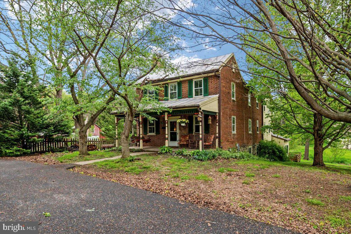 If you have any questions or wish to submit an offer, please text or email me as I'll have limited cell service between June 1 - 19th. I WILL get back to you.
Looking for a home that is an exceptionally beautiful, spacious haven for your family, while conveniently located to all the services you need? Look no further. Discover the peace and tranquility that are the hallmark of this amazing historic 1.85-acre homestead only a few miles from Carroll County Memorial Hospital, the Westminster shopping corridor, and is within walking distance to the charming town of New Windsor and its restaurants, post office, and convenience store.
Head up the paved driveway to immediately escape to your own retreat. Meander through the ancient black walnut trees, fruit trees, and perennial flower and herb gardens. Imagine gathering fresh eggs from the hen house, tinkering in the workshop, or harvesting all the veggies your family can eat from the eight raised beds in the high tunnel/greenhouse and irrigated garden beds.
With two residences (the Civil War era farmhouse and cottage), this unique homestead presents many opportunities. Grow and sell your own produce and fresh eggs at the local farmer's market. Rent or AirBnB the cottage. Or better yet, with cable and internet access, this is also an ideal place to work from home. Commute to Frederick (25 miles), Baltimore (40 miles), or Washington (60 miles).
The Farmhouse exudes historic energy and charm: original hardwood floors, two wood-burning fireplaces, porches on every level, the metal roofs, and the spacious gathering room in the middle of the home. The 1 bedroom, 1 bath cottage was originally the summer kitchen. A dairy barn with a spring and cooling milk trough, still stand. What are your ideas?
Important features:
Both residences have public water & sewer. (completely paid).
The sellers qualified for the agricultural tax deduction.
The following OUTBUILDINGS are included:
Barn, Garage, Shed, High Tunnel, Spring House, Workshop, Chicken Coop (and chickens if desired).
Garden Irrigation System - The functioning well can be used to irrigate the high tunnel and garden (free water).
See the list for equipment that conveys.
A gravel/asphalt circular driveway and chain link fence enclose both 20730 & 2732 Old New Windsor.
Potential for subdividing.
2730 & 2732 Old New Windsor can be purchased together.