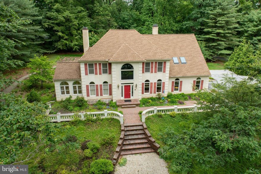 Nestled among specimen trees and landscaping designed for a designated Monarch butterfly  waystation is this stately Colonial, offering an abundance of upgrades and features.  

Beginning at the grand entry foyer with marble flooring and a curved staircase, the high ceilings and custom millwork will delight you.   To the left of the foyer is a formal living room with hardwood floors, which opens to a bright and airy conservatory with stone tile flooring.  On the opposite side of the foyer is a dining room, with custom wainscoting and French pocket doors, perfect for entertaining. The dining room is adjacent to the Butler’s Pantry with filtered water faucet, a walk-in coat closet, and a grand Chef’s kitchen.  The kitchen boasts ample cabinetry, granite countertops, stainless appliances, two dishwashers, complete with gas cooking, connected to the huge family room with a gas fireplace.  The kitchen and living spaces at the back of the home offer views of the stunning patios and gardens.  If this is not enough, a huge, private office with a gas fireplace surrounded by a custom mantel, marble surround, flanked by built-in bookcases is adjacent to the kitchen and family room. The embossed ceiling adds to the grandeur and warmth of this room. 

This level also includes a full bath with a bathtub and shower, adjacent to the mudroom with closet, just inside the attached two car garage.  There is a convenient exit from this full bath to the back yard.  A convenient powder room is located near the living room and conservatory. 

Ascend the grand staircase to the second floor, through a custom decorative door into the primary suite, which features a third gas fireplace, custom crown molding, a large storage/flex space, two walk-in closets and a fully renovated bathroom, with heated tile floors, custom sink, a soaking tub and a walk-in tile and glass shower. 

Five additional bedrooms on this level are great sizes, with generous closets.  Two hall baths and a second floor stackable washer and dryer complete this floor.  The third custom bath on this level also has radiant heat under the tile flooring in the shower room.  The artisan sinks in some of the bathrooms are truly special.

The lower level boasts a huge finished room that could be a single bedroom or converted to multiple bedrooms, which is adjacent to a large full bath with an artisan sink, custom vanity and a walk-in tile shower.  There is another large finished room with radiant heat in under the tile flooring that could be a bedroom, office, studio, exercise or yoga room.  This room has great closet space and there are three walk-in closets in the hall just outside this room. 

The unfinished part of the basement is extensive and offers newer utilities, a radon system, a walk-up with Bilco doors, and a second laundry area.  

The grounds are truly lovely, with pathways that surround the house, patios,  trees and other specimen plantings.   One can imagine spending time outside gardening, entertaining and relaxing in the peace and quiet.  

The level of upgrades in this custom home are unmatched in the area.   The roof, soffits, gutters and downspouts were new in 2018.  The dual zoned HVAC was new in 2014.  A tankless water heater was added recently.  There is a new stainless, double oven in the kitchen. A sump pump was also replaced recently.  There are numerous, newer mini-split systems throughout the home offering comfort at every level.