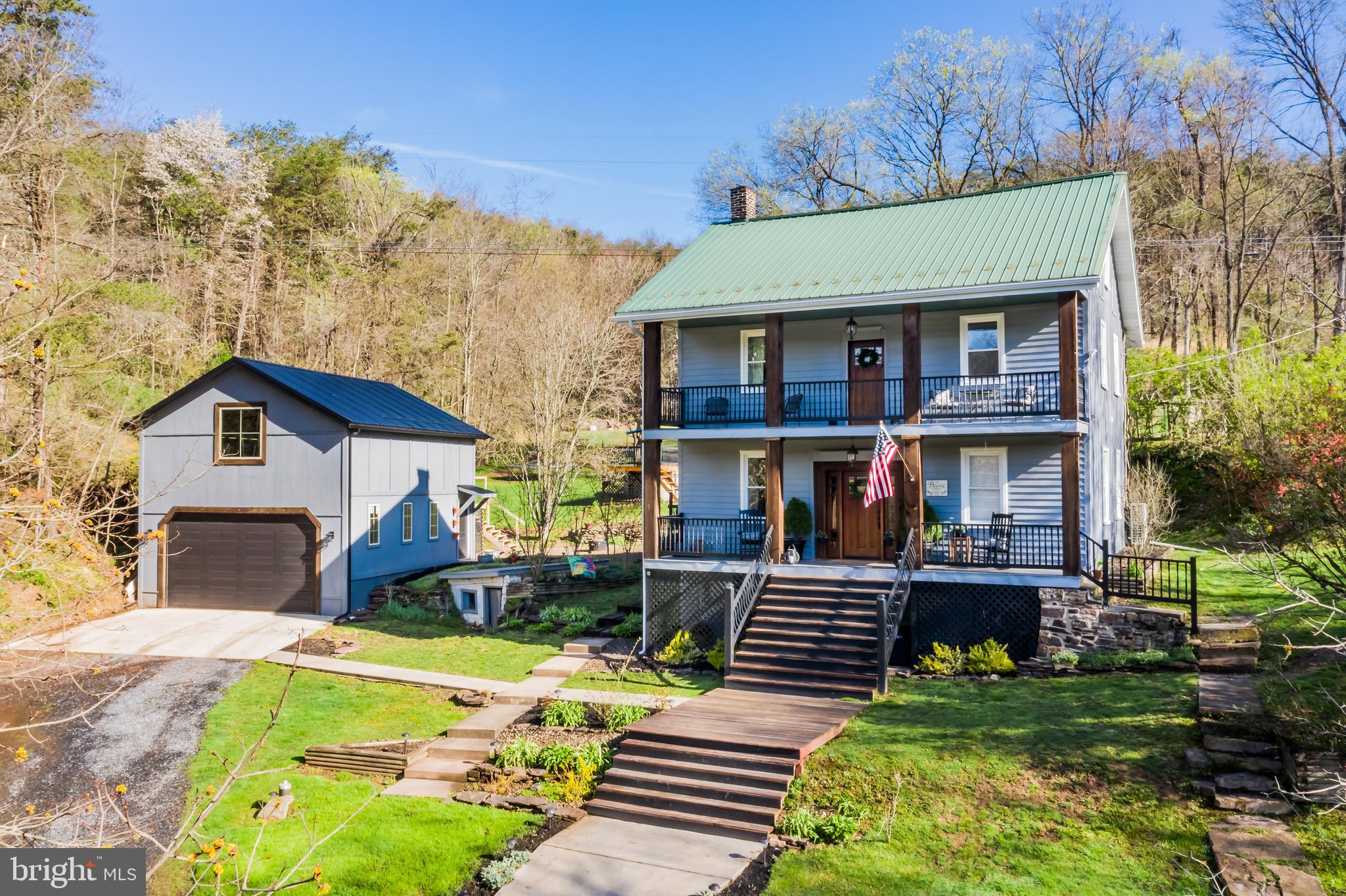 YOUR PRIVATE RETREAT AWAITS NESTLED IN THE HUNTINGDON COUNTY MOUNTAINS!   This home has been completely upgraded with spectacular features.  You'll first notice the welcoming covered front porch...ideal for all those cups of morning coffee where you'll take in the surrounding mountains and pastures.  Solid hardwoods throughout much of the main level with exquisite exposed beam ceilings and walls.  A beautifully detailed staircase greets from the foyer.  The great room offers soaring ceilings, loads of glass and is accented with a custom stone floor-to-ceiling FP.  The most discriminate of chefs will fall in love with the gourmet kitchen that offers custom built in cabinets, free floating shelving for knick-knacks, huge breakfast island, SS appliances, farm sink and so much more!  The dining area is perfect for 2 or 10!  Primary bedroom is conveniently located on the main level and offers stunning upgrades including a huge walk-in closet, upgraded lighting fixtures and relaxing primary bathroom.  The half bath on the main level is set off with a decorative barn door . Level 2 offers 3 bedrooms, all with ceiling fans, a beautiful upgraded full bath and laundry.  Level 3 has a bedroom and "bonus" room that would be ideal for a play room!  Gorgeous polished wood ceilings grace these two spaces along with unique ceiling fans.  Pavered patio is where you will dine al-fresco this summer!  The owner of this home will love the space in the huge detached 2 story garage.  VACATION AT HOME in your above ground pool with surrounding deck!  New Artisan well (5 years).  New gutters. This property offers so much more, all surrounded by nature and wildlife.  Don't miss living life tucked away from the traffic & noise of living in town...call today and make this HOME tomorrow!