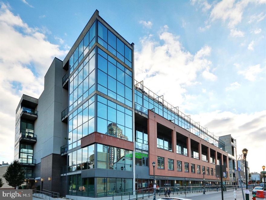 They simply don't build loft residences like this anymore - where authentic industrial character meets a layout masterfully optimized for maximum livable space and everyday functionality. This rare 2-bedroom + Office Space, which can be used as a 3rd bedroom, 2.5-bath penthouse loft on the prestigious Avenue of the Arts delivers the kind of luxury urban living that today's discerning buyers demand.

Step inside and experience soaring 10-foot ceilings, dramatic floor-to-ceiling windows, and cool slabs of exposed concrete in tonal grays that set the stage for a light-filled, contemporary interior. The open-concept floor plan flows effortlessly across engineered oak hardwood floors, creating an entertainer's dream with uninterrupted sightlines from the living area through the designer kitchen.

The chef's kitchen is appointed with Wolf and Sub-Zero appliances, quartz countertops with a seamless slab quartz backsplash, an in-unit dishwasher, and custom black-and-oak cabinetry accented by polished gold hardware - every detail curated for both style and performance. A custom built-in bar with wine cooler is perfectly positioned for after-work unwinding or effortless entertaining. Brand new HVAC unit installed a month ago and a tankless water heater was installed a year ago.

Throughout the residence, artfully designed custom cabinetry makes a statement - from the matte black built-in media center in the living area to the warm oak vanities in each bath. Sculptural lighting fixtures complement the industrial aesthetic while a dedicated home office space which is big enough to be used as a 3rd bedroom and supports today's work-from-home lifestyle.

Two private outdoor spaces - including a covered terrace - offer front-row seats to the stunning Center City skyline by night and vibrant street-level energy by day, rain or shine.

The owner's suite features a striking floor-to-ceiling window gallery wall that curves into the ceiling, flooding the room with natural light and framing panoramic city views. The spa-inspired en-suite bath boasts Porcelanosa tile floors, a custom dual vanity, and a walk-in frameless glass shower. The generously sized guest suite includes its own full bath with soaking tub, shower, frameless glass enclosure, and custom vanity.

This sale includes two deeded parking spaces in the secure, 24-hour monitored covered garage - a true rarity in Center City. One of the parking spots even has an electric charger installed for your EV vehicles. Building amenities include a sleek, modern lobby with 24-hour concierge service and low monthly condo fees.

Unmatched walkability to Philadelphia's best dining, boutique shopping, coffee houses, cultural venues, and public transit makes 1352 Lofts one of the most compelling luxury addresses in the city.