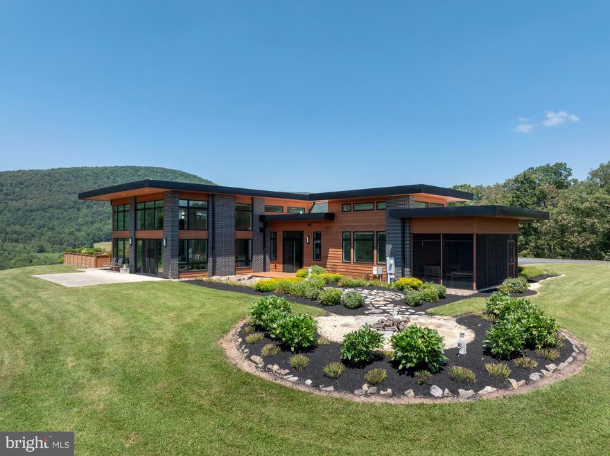 A one-of-a-kind architectural masterpiece set on 23+ private acres.

Meticulously crafted by Roeshot Construction Inc. with custom interior design by Jennifer Hendrickson, this 2-bedroom, 2.5-bath home is a sanctuary of luxury and tranquility. Wrapped in warm cedar wood siding and anchored by black obsidian brick with gray grout, the exterior sets the tone for the artistry within.

The home’s dramatic entry showcases a custom stone walkway, manicured front gardens, and six unique lighting zones in the courtyard for an unforgettable arrival. Inside you are greeted with radiant heated floors, a soaring great room with a floor-to-ceiling stone fireplace, and a stunning garden room with skylights for year-round greenery.

Every inch is custom — from the Porcelanosa kitchen tile and cabinetry to bespoke built-ins by Architect’s Millshop. Thoughtful features include sliding doors leading to multiple patios with panoramic views of the Pennsylvania Wilds, the koi pond, pool, and lush gardens.

Outdoors, enjoy an oversized cement patio with southwestern and western views, a cedar deck overlooking a Buddha and peony garden, and L-shaped planters surrounding a private garden retreat off the primary suite.

A fully hydrated organic garden and a unique orchard of apples, peaches, and pears create a vibrant, sustainable landscape—offering beauty, bounty, and peace of mind.

Energy-efficient with owned solar panels, radiant floors on both levels, and designed for harmony with the land, this home is only 8 miles from Bald Eagle State Park and Sayers Dam.

A rare legacy property where luxury meets nature.