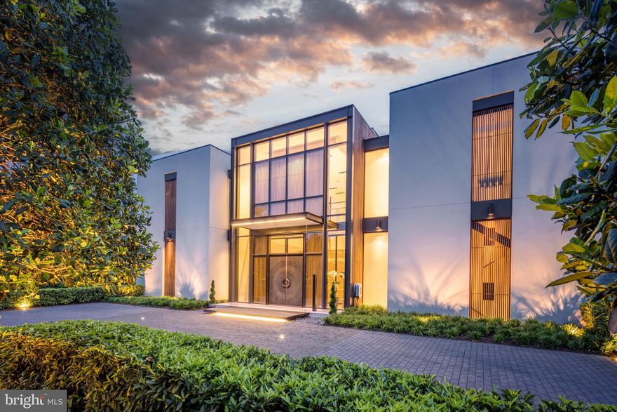 MCLEAN'S GOLD COAST:  D.C. Metro-Area's most desirable landmark neighborhood. This custom residence, designed by well-known architect Mark McInturff and built by Added Dimensions Constructions, is exceptional in every way: design, construction, and finishes.  Concrete, steel & glass embody the symmetry that eludes European elegance to withstand the test of time. Natural light bathes 8,367 square feet of beautifully curated, conditioned interior space. The home offers convenient accessibility with an elevator from an expansive garage to all floors. A reception hall enhanced by bronze mesh sliding screens offers elegance and options for added privacy. With soaring 25-foot ceilings, the captivating Great Room sets a grand and sophisticated ambiance with radiant white limestone floors and a signature chandelier by Manooi, adorned with Swarovski Crystals. Skylights and floor-to-ceiling windows create an open and airy atmosphere. The gourmet kitchen features top-of-the-line Gaggeneau appliances, custom Boffi Italian cabinetry, and a European maritime-themed center island by Alno. The flooring combines high quality white oak, white limestone, with beautiful polished concrete in the heated garage. Technological innovation integrates seamlessly with automated lighting, audio, and video systems. Automatic shades and screens provide comfort throughout the home. Sustainability meets high-efficiency with hydronic radiant heating and a geothermal system. The spacious primary suite offers a sitting area, walk-in closets, and two luxurious baths with a soaking tub, fog-free mirror, and steam shower. The meticulously designed hardscape includes a travertine lounge patio with a gas fire pit and BBQ station, overlooking lush, parklike gardens and a picturesque creek. A saltwater, waterfall infinity-edge, heated swimming pool adds to the private oasis. Prepare to be captivated by a truly extraordinary home that redefines contemporary luxury and the highest quality at its finest.
