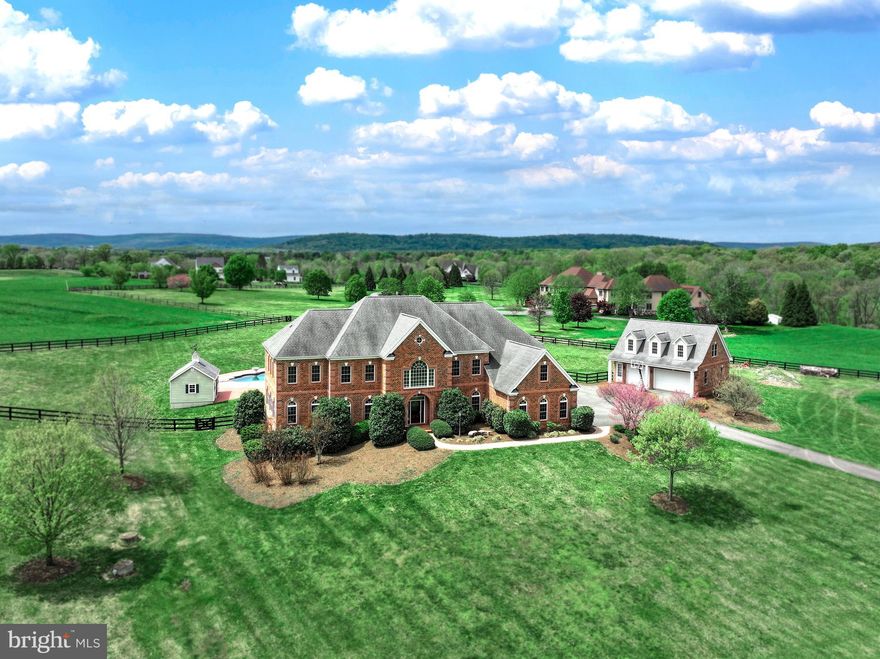 No HOA & 5 mins to Town! Custom built by Sgarrella Brothers Construction, perfectly situated on a hill with sweeping pastoral views, on a sprawling 12.79-acre lot, this exquisite brick home offers unparalleled luxury. Revel in the refined elegance of 3 meticulously finished floors, featuring 5 generously sized bedrooms, 5 full bathrooms, 2 half baths, and 2 laundry rooms. Car enthusiasts and hobbyists will appreciate the 6 garage spaces, comprised of an attached 3-car garage, plus a detached 3-car garage with an apartment above, ideal for guests or as a potential rental opportunity. The apartment has a living area, kitchenette, bedroom and full bathroom bringing the property total to 6 bedrooms, 6 full bathrooms, and 2 half baths. <br> <br> Upon entering, step into a grand two-story foyer that leads into a soaring two-story family room, anchored by a stunning stone gas fireplace. This home is adorned with deluxe crown and chair moldings, wainscotting, and two staircases, enhancing the character and elegance. The heart of this stunning residence is a chef-inspired gourmet kitchen, with a gas 6-burner plus griddle Wolf range, two Asko dishwashers, a warming oven and beautiful granite countertops. The kitchen opens into expansive living spaces that flow seamlessly outdoors to a Viking equipped outdoor kitchen situated on a slate stone porch. Perfect for entertaining, the estate boasts an alluring heated saltwater pool complete with fountains and light-synchronized displays, a relaxing hot tub, and equipment pool house. Luxury continues with a sophisticated Leviton dimmer lighting system and an integrated speaker system throughout, creating an ambiance of both high-tech convenience and welcoming comfort. Hardwood floors grace the entire main level and extend through the upper hallway. The floors have been newly refinished on the main level and are simply gorgeous! Additionally, the interior of the home has been freshly painted. The upper level features a spacious primary suite, complete with a tray ceiling, inviting sitting area, his-and-her spacious walk-in closets, and an ensuite primary bathroom with a jetted bathtub. There are four additional bedrooms, two of which feature ensuite bathrooms, while the other two share a convenient Jack-and-Jill bath. Additionally, an upper-level laundry room adds to the convenience, complementing the main-level laundry room located off the mudroom. The lower level is an entertainer’s delight, featuring a media room and fully equipped bar with a Bosch dishwasher and an icemaker, perfect for hosting gatherings. The bonus room and full bathroom on the lower level provide convenience and versatility, ideal for a variety of uses such as a home gym. The grounds are a true showpiece, framed by elegant 3-board fencing, offering ample space for equestrian pursuits, with no HOA. Bring your horses and build your dream barn! The paved driveway welcomes you to this exceptional estate, combining luxurious living with the freedom to enjoy your passions. Located just minutes from Purcellville and close to major routes for ease of commuting, this home offers the perfect balance of peaceful countryside charm and seamless access to town amenities. Comcast/Xfinity High Speed Internet, Cat 5e cabling throughout House. Property is in land use and the seller is not responsible for roll back taxes should buyer take property out of land use. Shown by appointment only. <br> <br> UPDATES: Painted House Interior 2024 - Painted Exterior Trim 2024 - Refinished Main Level Hardwood Floors 2024 - New Carpet in Primary Bedroom 2024 - Primary Bath New Shower Doors 2024 - Bosch Dishwasher in Bar 2023 - Media Room New BenQ 4K HDR Projector 2023 - New Gas Furnace Zone#1  2023 - New Pool House Pumps 2020 - New Heat Pump Upper Level 2019 - Pool Deck Brick Pavers 2015 - Pool House Constructed 2014 - Added Rear Porch & Viking Outdoor Kitchen 2014 - Installed Rear Yard Fence 2010 - Paved Driveway 2009