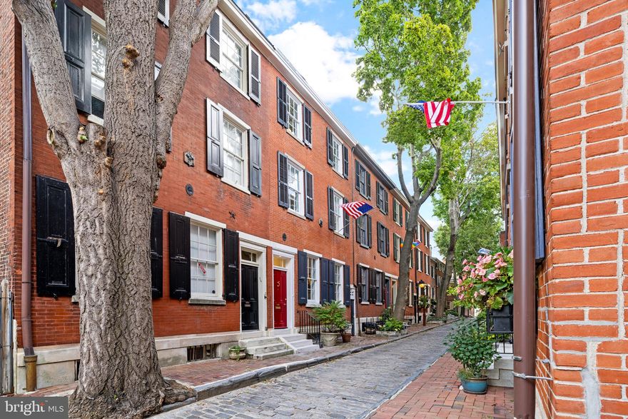 Charming Quintessential Society Hill
The ideal combination of character and convenience is  rarely available in Society Hill. This is the quiet, premier block of American St.  The picturesque cobblestone street is only one block in length, running between Delancey and Spruce.  318 S American St has been restored to its original charm and freshly painted throughout. Outstanding crown molding, chair rail and fireplaces have recently been been recreated. Step into the  living room and dining room filled with natural light. Don’t miss any of the special features. The fireplace mantels are both custom.  The built in china closets and magnificent James R Moder chandeliers make this a very inviting space.  The private patio area between the dining room and the kitchen is the perfect spot for morning coffee or a glass of wine in the evening.  The kitchen is light and bright with high end appliances. A private  powder room was just added in the back hall, across from the beautiful cherry back door.  Step outside the back door to a private garden.  Right beyond the garden wall is your own, deeded parking space.  The lower level is beautifully finished with a brick fireplace, white oak hardwood floor, exposed beams and numerous builtins.  The laundry room and another, new powder room are conveniently located right off the family room area.  On your way to the second floor, don’t miss the office with unique window, hardwood floors, and builtin cabinetry.  The second floor houses the primary bedroom with a full wall of closets and an amazing new bath with large, custom, double vanity, soaking tub, glass shower with marble tile, fireplace, and cubby as well as storage cabinets.  As you go up to the third floor you will find yet another outdoor space.  There is a cozy roof deck.  The third floor has two more bedrooms and a shared bath.  The front bedroom has an original fireplace.
This is a rare opportunity to live in a carefully restored historic property with original pine flooring and six fireplaces, while enjoying the benefits of an all new 2 zone HVAC system, water softener, and water filter, as well as PARKING right outside your door.  Parking fee is $1200 annually to association.