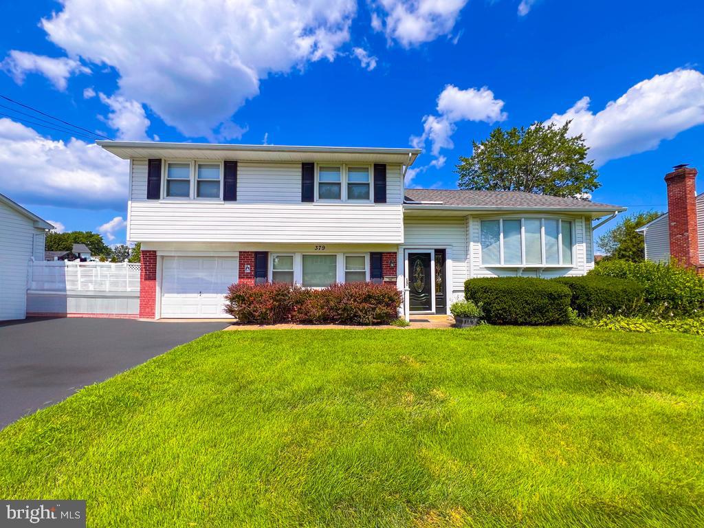 Welcome to 379 Patton Drive - here is a rare opportunity to own a single split level in the highly desirable and peaceful neighborhood of Warminster Heights. The lovely home is set back from a nice sized front lawn with established landscaping. The rear of this home features a beautiful sunroom addition with steps leading down to a paver blocked patio. The sprawling back yard is spacious and well maintained with a storage shed. The garage has a convenient opener with 2 transmitters included.
Enter from the front door into a family room on the left, with a convenient laundry room, half bath and exit to the rear patio and yard. Up a few steps to a generously sized living room, eat in kitchen, dining room and the gorgeous sunroom. The upper level features 3 bedrooms and a full bath.
Don't miss the chance to see this lovely home - it won't last! Convenient to shopping and SEPTA Regional Rail. One year Home Warranty package included.
Please note some personal items have been digitally removed from photos solely to show clear space.