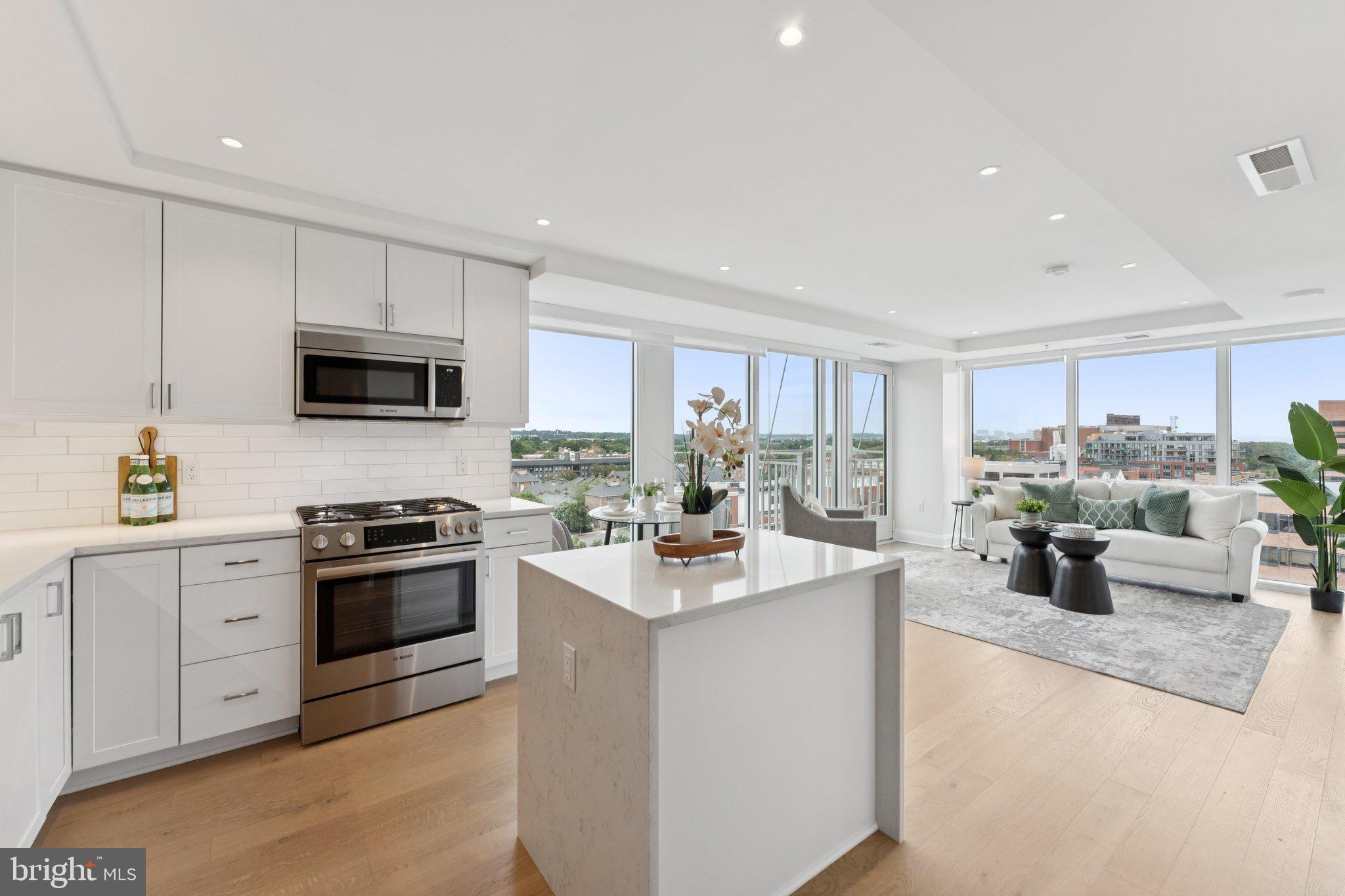 Welcome to The Venue Condominiums, a newer development where modern design and everyday convenience come together in the heart of Old Town Alexandria. This bright 1-bedroom corner unit features an open layout with dramatic floor-to-ceiling windows that fill the space with natural light throughout the day. Step out onto your private balcony to enjoy fresh air and sweeping views of Old Town.
The gourmet kitchen is a standout feature, offering stainless steel Bosch appliances, a gas range, sleek white cabinetry, and a classic subway tile backsplash. The living area flows easily into the dining and kitchen spaces, making it great for relaxing or entertaining. The bedroom includes a large walk-in closet with built-in organizers, and the bathroom offers modern tilework and a glass-enclosed shower. One garage parking space and an additional storage unit convey with the property.
The lobby at The Venue is staffed with a concierge and on-site building manager. Residents also enjoy a rooftop terrace with panoramic views of the Potomac River, DC Monuments, National Harbor, and Old Town’s skyline. Other amenities include a sky lounge with cocktail bar and fireplace, a fitness center with Barre studio, grilling stations, and a rooftop glass fire table for evenings under the stars.
The Venue’s location puts you within walking distance of Old Town’s best dining, shops, and the Mount Vernon Trail. Trader Joe’s, Harris Teeter, and the Farmers Market are close by, and King Street’s historic charm is just a short walk away. Getting around is easy with National Airport 10 minutes away, the Braddock Metro less than a mile from your door, and a DASH bus stop right across the street.
Experience the perfect mix of modern style, convenience, and community at The Venue Condominiums. Schedule your private tour today.