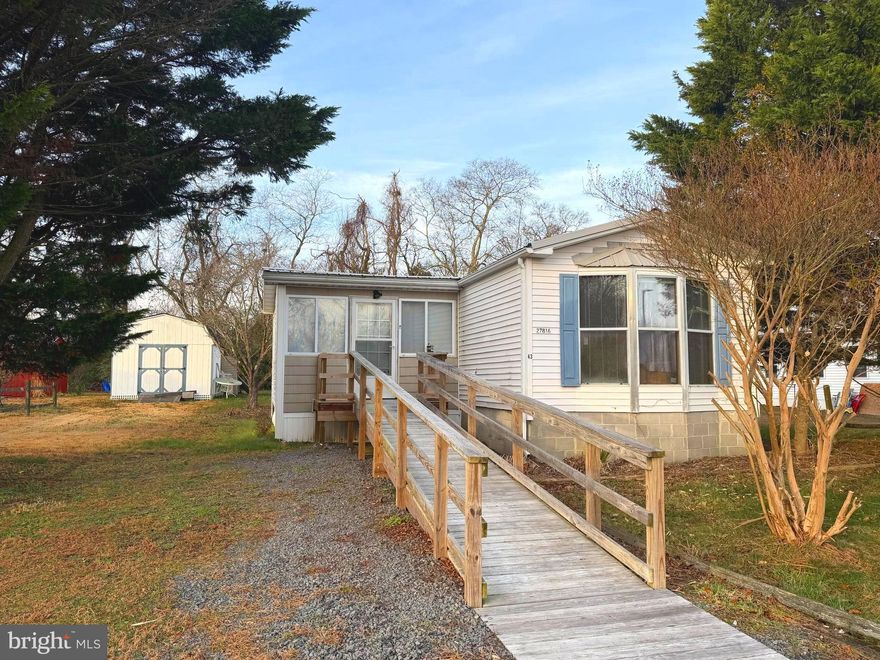 Back on the market through no fault of the seller. NO GROUND RENT! 2-Bedroom, 2-Bath Mobile Home on its own land. Discover a home in the heart of the Millsboro/Long Neck area! Home offers comfortable living with fantastic potential. The spacious interior boasts a functional layout, complemented by a generously sized 3-season room perfect for enjoying the outdoors in comfort. A large shed provides ample storage for tools, hobbies, or outdoor gear. Home also features a new ramp out front for easy access to inside the home. Trash, and Road Maintenance are included for $52/month.

While in good condition, this home is being sold as-is making it an incredible opportunity to add your personal touch with a few upgrades. Minutes from grocery stores, restaurants, shopping, and boating adventures—the perfect hub for enjoying all that coastal Delaware has to offer.

Don’t miss this chance to own a home with great potential! Schedule your showing today and bring your vision to life! Buyer is responsible for all transfer fees.