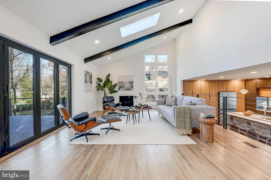 Lake Barcroft – Stunning Remodel by MM Design Co.

Prepare to be captivated by this 4-bed | 3-bath masterpiece, thoughtfully reimagined to balance modern luxury and functional living. With hardwood floors throughout, gorgeous light fixtures, high-end finishes, and designer touches at every turn, this home is truly one of a kind!

Step onto the inviting front porch/patio and into the entry, where style and functionality converge. To your left, an entry-level bedroom doubles as the perfect office, while to your right, the showstopping open-concept kitchen awaits. Custom contemporary cabinets, sleek stainless steel appliances, and expansive quartz countertops with a large island/breakfast bar set the stage for culinary adventures and memorable gatherings.

Ascend a few steps up to the expansive living/dining room which is nothing short of breathtaking. Vaulted ceilings soaring overhead, three large skylights, and floor-to-ceiling windows bathe the space with natural light and blur the boundaries between indoor and outdoor living. A wood-burning fireplace anchors the room, and 12-foot bifold doors open to an expansive Trex deck, offering a chic Cali vibe. This level is surrounded by striking modern steel railings and boasts a built-in bar and a spa-like full bathroom.

The upper level offers a luxurious primary suite featuring two closets (including a walk-in) and an oversized ensuite bathroom with dual rain showers and a double vanity. The third sizable bedroom, an elegant full bathroom, and laundry round out this level.

The lower level includes a spacious family room with a wood-burning fireplace, a fourth bedroom, and access to the backyard. Situated on a private half-acre lot, the outdoor space provides plenty of room to relax, entertain, or play, enhanced by modern landscaping, a stylish walkway, and that impressive Trex deck.

Located on one of Lake Barcroft’s most desirable streets and just blocks from the beach, this contemporary showpiece epitomizes the sought-after lifestyle of this unique community. With five sandy beaches for swimming, boating, and fishing, plus easy access to East Falls Church Metro, commuter routes (395/495/66), the Pentagon, DC, and Tysons, this is your chance to enjoy the perfect blend of serene lake living and city convenience.