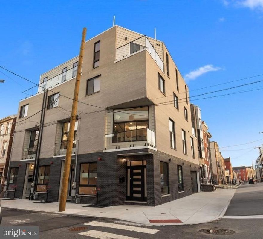 Welcome to The Estates at Queen Village, a rare opportunity to own a brand new custom luxury townhome in one of Philadelphia’s most sought-after and culturally rich neighborhoods. Surrounded by tree-lined streets, award-winning restaurants, artisan cafés, and historic architecture, this 3,600+ sq. ft. corner masterpiece delivers the ultimate blend of city living, modern design, and suburban-style space — all with the added benefit of a full 10-year tax abatement. Perfectly positioned on a sun-drenched corner lot, this end-unit home is wrapped in light and elegance, offering unmatched privacy, elevated finishes, and the charm of a quiet block just steps from premier amenities. Designed with a striking white brick façade, the exterior honors traditional Philadelphia character while introducing refined, modern craftsmanship throughout. Inside, this 4-bedroom, 4.5-bath residence showcases thoughtful architectural detail, premium materials, and custom designer touches at every turn. The one-car garage features epoxy-coated floors, an electric vehicle charger, and double garage doors for enhanced privacy and security—a rare and valuable feature for city living. A tailored mudroom with built-in storage and direct garage access provides a seamless and practical entry point. The finished lower level offers radiant heated floors, a sleek wet bar with wine fridge, a beautifully tiled spa-style bathroom, and a versatile bedroom ideal for guests, an office, or in-home gym. A convenient first laundry area completes the lower level. A floating staircase with glass and aluminum railings leads to the open-concept main floor, where soaring 12-foot ceilings, wide-plank white oak floors, and expansive windows bring in abundant natural light. The formal living area is anchored by a dramatic gas fireplace and flows effortlessly into the dining space and chef's kitchen. Outfitted with custom European cabinetry, a full suite of Viking appliances, and a bold waterfall-edge quartz island, the kitchen is as functional as it is striking. A chic powder room with a smart toilet and LED mirror adds a layer of contemporary polish. The third level is a dedicated sanctuary for the primary suite, featuring a custom accent wall, two large walk-in closets, and a spa-like bath complete with radiant heated floors, a freestanding soaking tub, frameless glass rain shower, floating double vanities, LED mirrors, and full-height designer tilework. The fourth level offers two additional bedrooms, including an en-suite with a private balcony, plus a third full bathroom and second laundry room for added convenience. A stylish wet bar creates the perfect lead-in to the crown jewel of the home: a private rooftop deck finished with fiberglass tile flooring, custom lighting, and unobstructed panoramic views of the Philadelphia skyline. Whether entertaining under the stars or enjoying quiet mornings above the city, this space delivers a true urban retreat. With high-efficiency mechanicals, top-tier fixtures, and meticulous design, 246 Montrose Street redefines modern luxury in a historic setting. This one-of-a-kind corner residence offers the rare opportunity to own new construction of the highest quality in the heart of Queen Village. Your luxury urban sanctuary awaits.