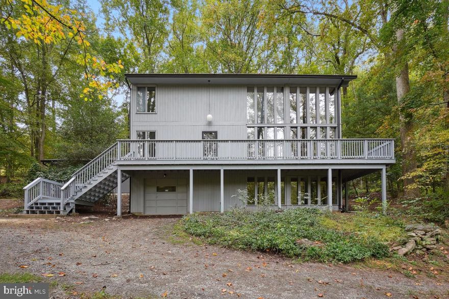 Nestled within a serene, wooded sanctuary, this exceptional custom-built contemporary home effortlessly marries the indoors with the great outdoors. Expansive windows at the front and rear of the residence beckon nature inside, allowing you to bask in the natural splendor that envelops this enchanting abode. The property is a haven, boasting privacy, mature trees, and a gentle stream gracing its front, creating a tranquil and idyllic backdrop for life's most cherished moments. Whether you're entertaining guests, hosting family gatherings, unwinding after a long day, or simply seeking solace, this home offers it all. If you like to hike, just across the street is access to the "Seneca Greenway Trail" with over 24 miles of trails leading all the way to the Potomac River.  Key Features Include. 1. Breathtaking Views & Stunning Spaces - One side of the property features dramatic, floor-to-ceiling windows with a two story stone fireplace that artfully frame the picturesque surroundings, granting you the privilege of enjoying the beauty of every season from the comfort of your own home. 2. Elegant Living: A two-story living room with a fireplace serves as the heart of this residence, providing a cozy ambiance during chilly evenings and breathtaking views from two-story windows on two sides. 3. Versatile Layout: The property includes two separate garages, a two car garage and a four car garage. The four car garage features expansive windows on one wall, cathedral ceilings, a lift, and a service pit. The lift can be removed to create an expansive studio, offering a versatile space tailored to your desires. 4. Spacious Bedrooms: With four bedrooms, there's ample space for relaxation and privacy, ensuring every family member has their own sanctuary. 5. Large Basement: Equipped with a wood stove and a sizable room ideal for an additional office space, the basement New Deck, refinished hardwood floors, and fresh interior and exterior paint. 8. No HOA Fees: Enjoy the freedom and flexibility of homeownership without the constraints of Homeowners Association fees. This property empowers you to personalize your space according to your preferences.  This ideal location strikes the perfect balance between seclusion and convenience. It's a tranquil retreat in the heart of nature, yet only a 3-minute drive from I-270, ensuring that essential amenities are never far away. MUST SEE!