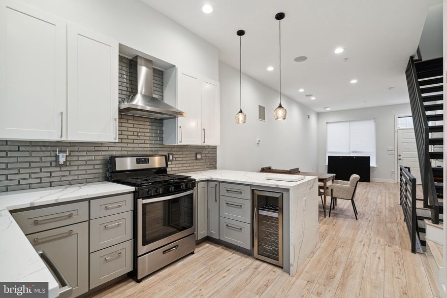 Welcome to 1448 N Myrtlewood St, a stunning 4-bedroom, 3-bathroom home located on one of the most desirable blocks in vibrant Brewerytown. Nestled on the 1400 block—a quiet stretch lined almost entirely with new construction single-family homes—this property stands out with style, space, and thoughtful upgrades, plus excellent FREE street parking. Step inside to a beautifully designed open-concept layout, featuring Calcutta quartz countertops, a sleek waterfall peninsula, custom backsplash, and stainless steel appliances. The elegant, modern touches continue with floating vanities in the bathrooms and rich hardwood flooring throughout. The finished basement adds additional living space, perfect for a home office, media room, or guest suite. Retreat to the master suite, where you’ll find a striking tray ceiling, a built-in wine fridge, and direct access to the private roof deck, offering expansive city views. Additional features include dual-zone HVAC for year-round comfort and smart climate control. This home also comes fully equipped with upgrades rarely found at this price point, including a mounted 70-inch TV with an integrated sound bar and subwoofer, and CB2 kitchen furniture, all included for your convenience. Located just steps from 29th & Girard, you’ll enjoy easy access to public transportation, major highways, and some of Brewerytown’s most beloved restaurants, including Green Eggs Café, Rybrew, and Spot Gourmet Burgers. With high-end finishes, smart upgrades, and unbeatable location, 1448 N Myrtlewood St is the perfect place to call home.