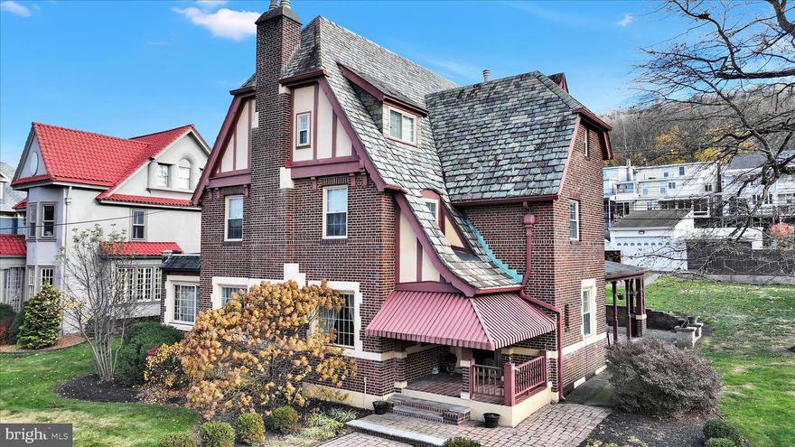 Historic Tudor Revival with Timeless Charm and Modern Luxury

Step back in time while enjoying every modern comfort in this stunning 1929 Prohibition-era Tudor home. Rich with architectural character, this brick and stucco residence features a classic slate roof, chimney pots, and a terra cotta tiled front porch, evoking the elegance of a bygone era.

Upon entry, the inviting foyer opens to a large grand hallway which lends access to the formal living room and dining room, perfect for entertaining. Original hardwood floors, French doors, and vintage light fixtures flow throughout, preserving the home’s authentic charm. A thoughtfully designed updated kitchen blends historic character with contemporary convenience — featuring granite countertops, stainless steel appliances, a double wall oven, wine fridge, custom cherry cabinetry, and a generous center island. Enjoy morning coffee in the adjoining sunroom, bathed in natural light.

Dual staircases lead to the second level, where original woodwork, glass doorknobs, and period details grace each of the four bedrooms. The primary suite offers a touch of luxury with its marble-tiled en suite bath, complete with gold-plated fixtures, whirlpool tub, and separate shower. A second full bath features a claw-foot tub, bidet, and brass fixtures, maintaining the home’s refined vintage aesthetic.

The third level provides flexible space — ideal for a guest suite, home office, or studio — and includes a large cedar closet. 

Downstairs, the finished basement offers a family room with a wood-burning fireplace, half bath, and laundry room with a convenient laundry chute serving all three floors.

Hidden behind an unassuming wooden door lies one of the home’s most remarkable features: a Prohibition-era speakeasy bar, complete with warm wood paneling, antique sconces, and a pass-through window to the family room with wood-burning fireplace — the perfect setting for intimate gatherings or themed parties.

Outside, a hardscaped patio leads to a heated oversized two-stall garage offering additional attic and basement storage.

Blending historic craftsmanship with modern updates, this one-of-a-kind Tudor residence is more than a home — it’s a living piece of history.

Don’t miss the opportunity to own this extraordinary property!