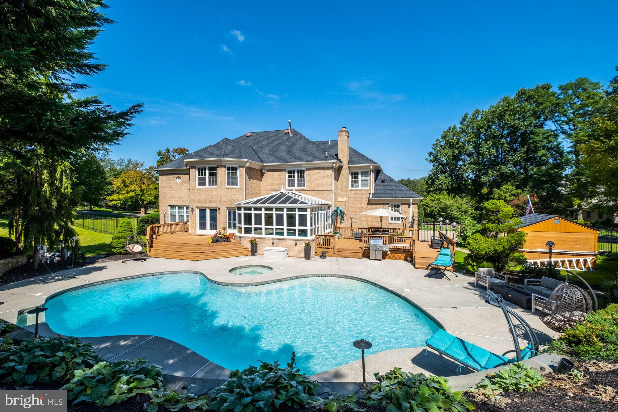 Beautifully updated and maintained French Colonial is sitting magnificently on a beautifully manicured 1.22-acre corner lot, with a circular driveway in the prestigious Normandie Farm Estates, only 1 mile from Potomac Village. Embodying the essence of style and Country Club features, this sun-filled home features a grand 2 story foyer, banquet-sized dining room, 2 story family room w/dramatic stone fireplace, a living room w/fireplace, and wet-bar, an oversized chef's gourmet kitchen island which boasts a 6 burner gas cooktop, 2 dishwashers, double ovens, custom Italian cabinets, granite, lighting, pantry and breakfast area with privacy tinted glass doors opening to the Trex deck on one side and the custom sunroom overlooking the pool and hot tub with a brand new wall unit air conditioner. The sunroom exits out to another Trex deck with a large seating area. A beautiful library/office with custom built-ins, a stylish powder room, and laundry room complete the main level. The curved staircase leads you to the private living quarters and into the spacious owner's suite with a gas fireplace, his/her walk-in closets, a half bath and owner's bath with double sinks, a whirlpool tub, custom glass-enclosed shower with bench and water closet. Three additional large bedrooms, two of which are interconnected with a Jack & Jill bath and one with an ensuite bath, are also equipped with walk-in closets. The lower level offers a movie theater, billiard room, wine cellar, bar, and lounge area perfect for entertaining. A 5th bedroom, also with a walk-in closet and en-suite bathroom. Another room has been created with an en-suite bathroom would make a great gym. A large storage room with a massive cedar closet wraps up the lower level. The many upgrades include the new architectural shingle roof, exterior security camera, custom kitchen with high-end appliances and finishes, marble flooring, and Brazillian cherry hardwood throughout, all of the bathrooms have been updated with high end fixtures (Toto, Grohe), new two zoned HVAC system, and new ductless A/C unit in the custom-built sunroom, all new pool equipment (heater, blower), the pool has also been resurfaced, concrete driveway and more! There is an oversized 3 car side load garage, along with a fenced rear yard! This home has a floor plan perfect for everyday casual living, and grand entertaining while still being able to social distance. View and walk through the 3D model here http://my.matterport.com/show/?m=dg1KFXejAps
