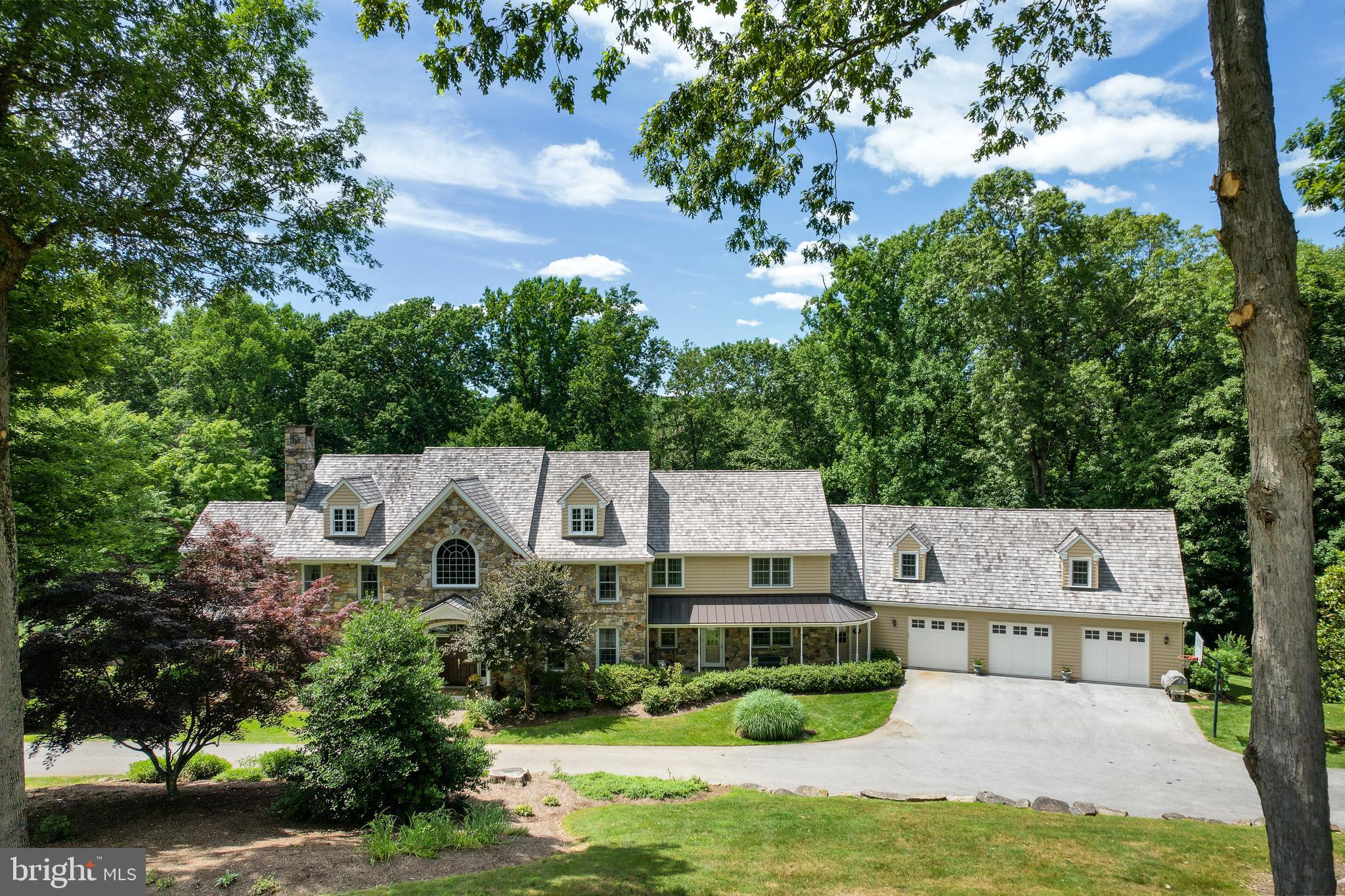 Nestled in a beautiful cul-de-sac of Chester Springs, 6 Douglass Lane is located in the highly desirable Douglass Lane subdivision—consisting of 9 custom Birchrun Builders homes. This elegant custom-built traditional farmhouse has 7600 sq. ft. and is located on 5.5 acres. Seclusion and privacy underscore this 5-bed, 6.3-bath, and 3-1/2 car garage home. Enter through a spectacular two-story foyer with an arched clerestory window, grand floating staircase, wainscoting, and beautiful hardwood floors with walnut inlay borders. To your left is a formal living room with a gas fireplace and to your right a formal dining room with wainscoting and beautiful crown molding. The front of the house has two additional side entrances that lead to an open floor plan with a gourmet kitchen, breakfast room, cafe, great room, formal office, music room, mudroom, screened-in porch with cedar decking, and two half-baths. The gourmet kitchen includes granite countertops, built-in Sub-Zero refrigerator, Thermador commercial cooktop oven, custom-made hood, double sink, Bosch dishwasher, cherry "Quality" Cabinets with a built-in pantry and hutch, a second oven built into the kitchen island. Two skylights provide plenty of natural light and the Italian tile flooring gives the kitchen a warm feel. Adjacent to the kitchen is a fully equipped "Quality" Cabinet butler’s pantry, along with a fourth pantry space. A delightful café with granite countertops, a hand-hammered copper sink, built-in Bosch microwave, dishwasher, and beverage center is right off the kitchen, and leads out to a weather-resistant, maintenance-free, Trex Composite Deck with cedar landing and steps—all designed for great entertaining! Cathedral ceilings, skylights, a full-stone masonry wood-burning fireplace, and a "Quality" Cabinets built-in entertainment center with a wet bar, cast-iron sink and granite counter define a fabulous step-down great room. Walk through a cozy music room and enter a relaxing screened-in porch with a decorative batten board ceiling. The formal office is a distinguished workspace that is freshly painted with molding, windowsills, crown molding and a private patio. A spacious mudroom with custom cabinets, sink area, double-stacked washer and dryer, along with two additional powder rooms complete the main level. Two separate stairways access the second floor landing for a very flowing floor plan. The upper level includes an expansive master bedroom with an over-sized en-suite, a large sun-filled sitting room, a bonus room, plus four additional bedrooms (all with their own unique en-suite.) The master en-suite is exceptionally large with two full baths, a huge walk-in shower, two walk-in closets, and a luxurious jetted tub. Also on the upper level is a laundry room with washer and dryer, granite countertops with a fantastic cast iron Kohler sink, plenty of cabinet space, and a huge walk-in closet. The bonus room, which can double for a second office, playroom, studio space, guest room, or in-law suite, adds an enormous amount of flexibility to the overall floor plan. The lower level of the home is the ultimate entertainment center with a unique custom-made Kountry Kraft Cabinetry bar with black Galaxy Granite counter- tops. In addition to the bar are a kitchenette and wine cellar. The wine cellar has exposed beams, built-in wine racks, and flagstone sills with 8” thick building stone wainscoting. Bead board and cedar wainscoting punctuate the perimeter of the lower level, as well as the half baths, which gives the entire space a unique lodge-like feeling. A stunning Coffered Ceiling, magnificent wood-burning fireplace, and access to a very private flagstone patio highlight the lower-level great room. In addition to a gaming spaces and a dining area there is another full bath with a large walk-in steam shower.