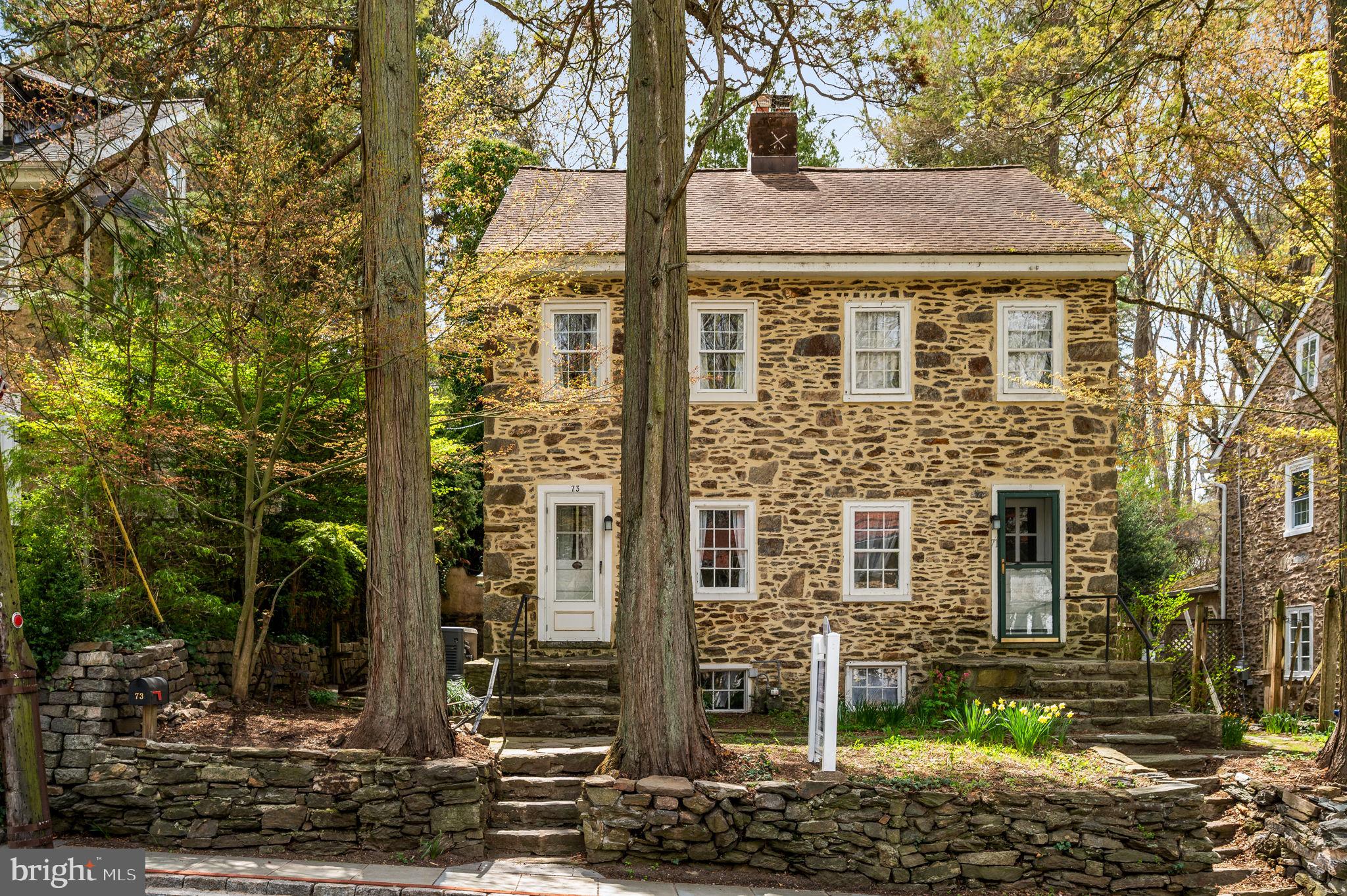Oh, the charm of 73 W. Rose Valley Road! This historic 3-bedroom Stone Mill house was transformed by William Price. Price founded Rose Valley in 1901, and built/redesigned these residences for the Mill workers after the Civil War. According to an unidentified article, probably written c.1904, they "have been turned into quaint and picturesque little homes" for the artisans and their families. The houses consisted of three twin houses on the south side of Rose Valley Road and a row block which had six units in a continuous row.
Built with 18-inch stone walls, the features of 73 W Rose Valley Road include original interior mill work and hardware, deep window casings, some original windows (note the swirls in the hand-blown glass), unusually high ceilings, exposed beams, wood oak and Pumpkin Pine floors throughout, a small fireplace in the Living/Dining Room, a Kitchen with door to a lovely courtyard with terraced stone gardens and steps up to each level. There is a built-in shed for garden tools and a built-in whole home system automatic generator by Honeywell. The Second Floor has 2 bedrooms and a full bath with an antique claw foot tub. The Third Floor is an entire bedroom with 1/2 bathroom and extra closet space. The Basement is functional. Knob & tube remediation in 2023. Updated/or new utilities.
The Borough of Rose Valley owns and maintains the parking lot across the street for you and your guests. For nature lovers, Maurice Saul Wildlife Sanctuary next to the “Old Mill” is a quarter of a mile away. The Borough of Rose Valley provides a large network of maintained walking trails through a forest path that wind around the Borough. In addition is Chadwick Wildlife Preserve. Also nearby is The School of Rose Valley, Hedgerow Theater (the oldest repertory theater in the country) offering presentations and classes, the Rose Valley Museum, the private Rose Valley Pool and Tennis club, Media’s renowned restaurants and shops, along with the Moylan-Rose Valley train station. The Wallingford train station, up Possum Hollow Road, is about a mile away. Here you will find a small post office, public library, restaurant, convenience store and Furness Park.
This historic Artisan’s Mill house offers a unique green and wooded preserved community of yesteryear with the necessities of today. The Philadelphia National airport is an easy twenty minute drive! Feel right at home here with local events, neighborhood watch, the Rose Valley Garden Club and the local Mayor available throughout the year.